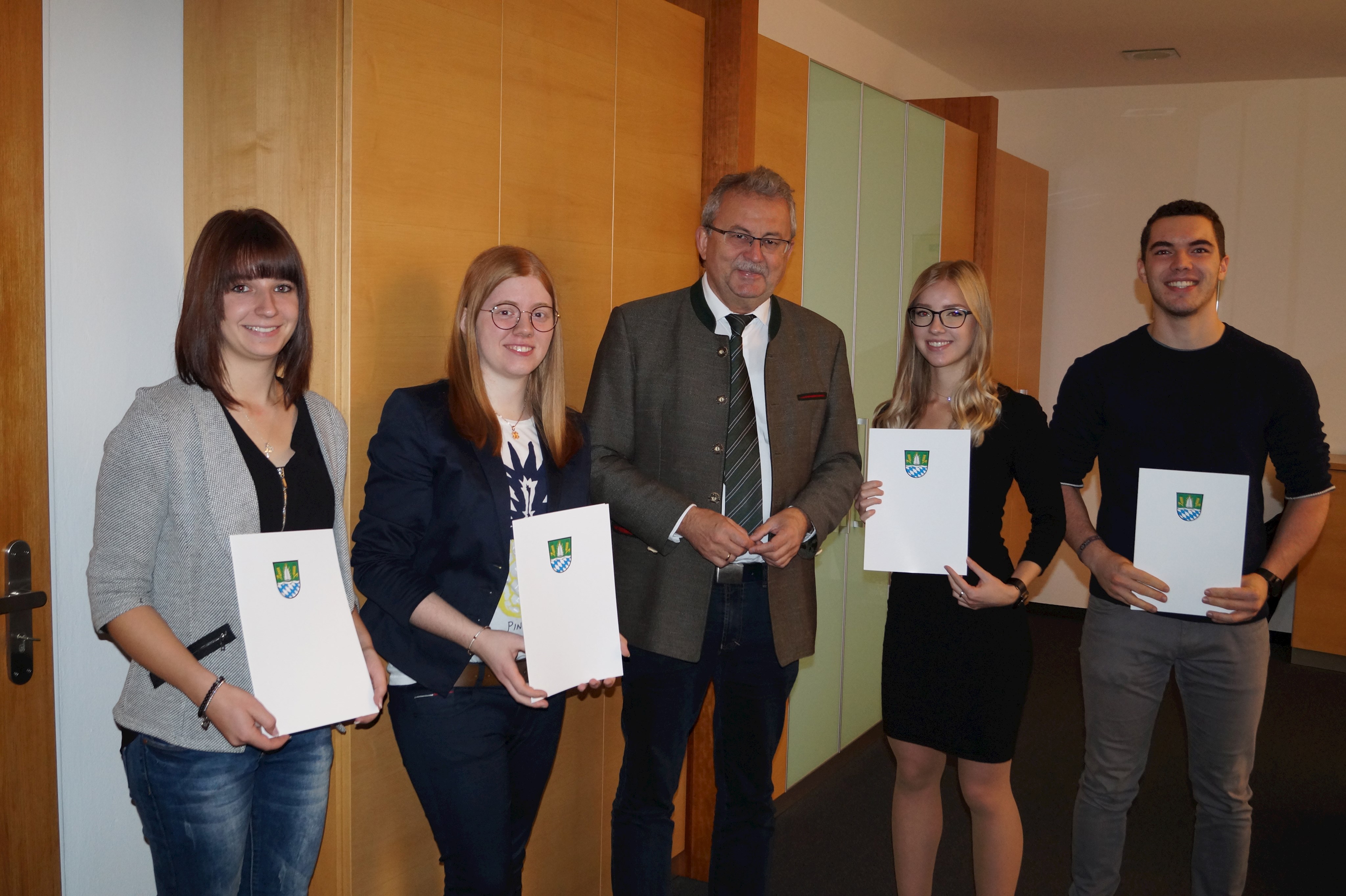 Anja Grundner, Lena Schmalzl, Laura Tremmel und Michael Ludwig (von links) werden von Landrat Josef Laumer persönlich in seinem Büro für ihre hervorragenden Leistungen beglückwünscht.