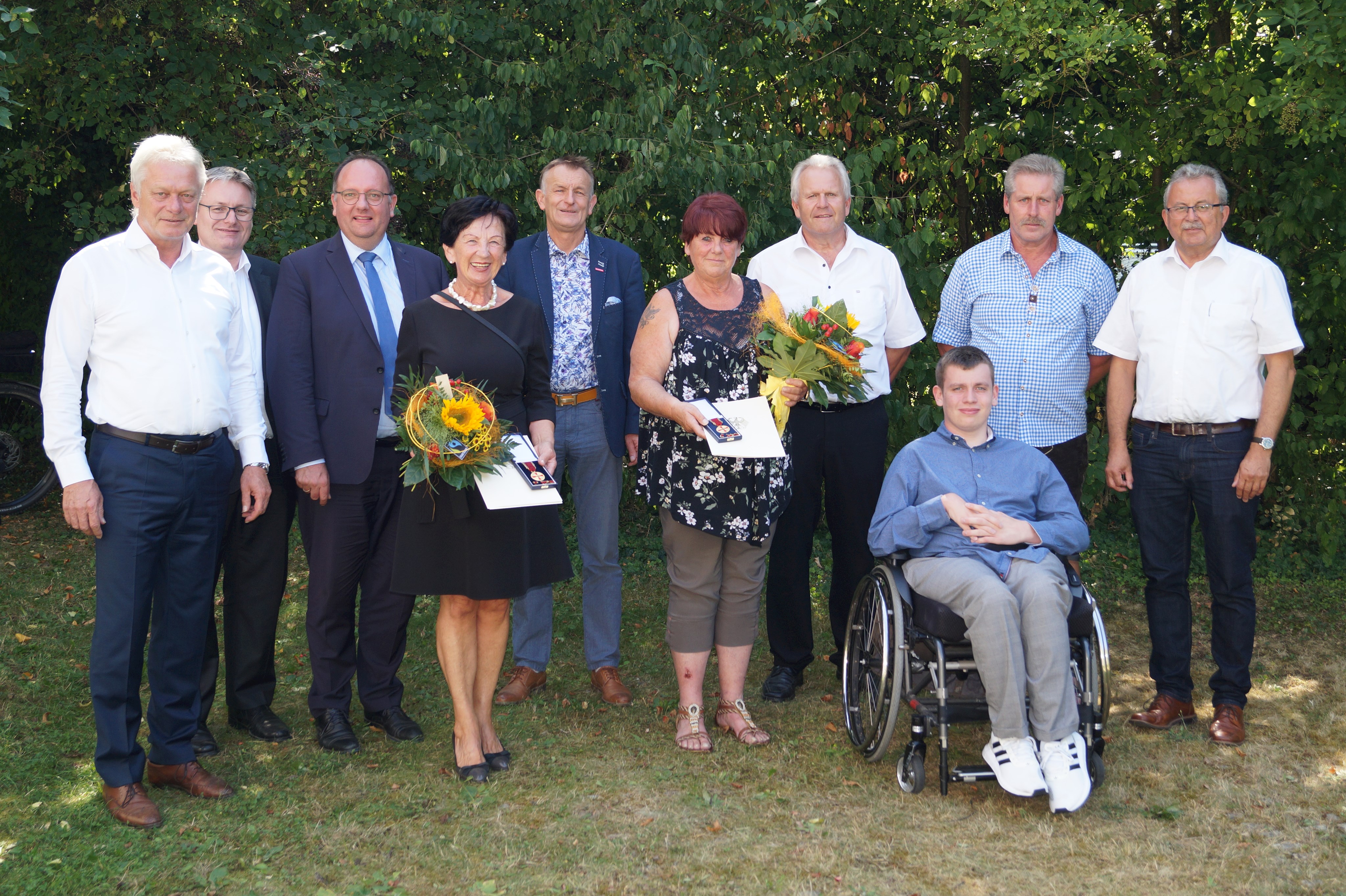 Ingrid Prebeck (links) und Petra Brunner (rechts) werden eingerahmt von Bundestagsabgeordnetem Alois Rainer, Landtagsabgeordnetem Josef Zellmeier, Geiselhörings Bürgermeister Herbert Lichtinger, Landtagsabgeordnetem Hans Ritt, Perkams Bürgermeister Hubert Ammer, Pascal Brunner, Ewald Brunner und Landrat Josef Laumer (von links) und stehen nach der Auszeichnung vor dem Landrat.