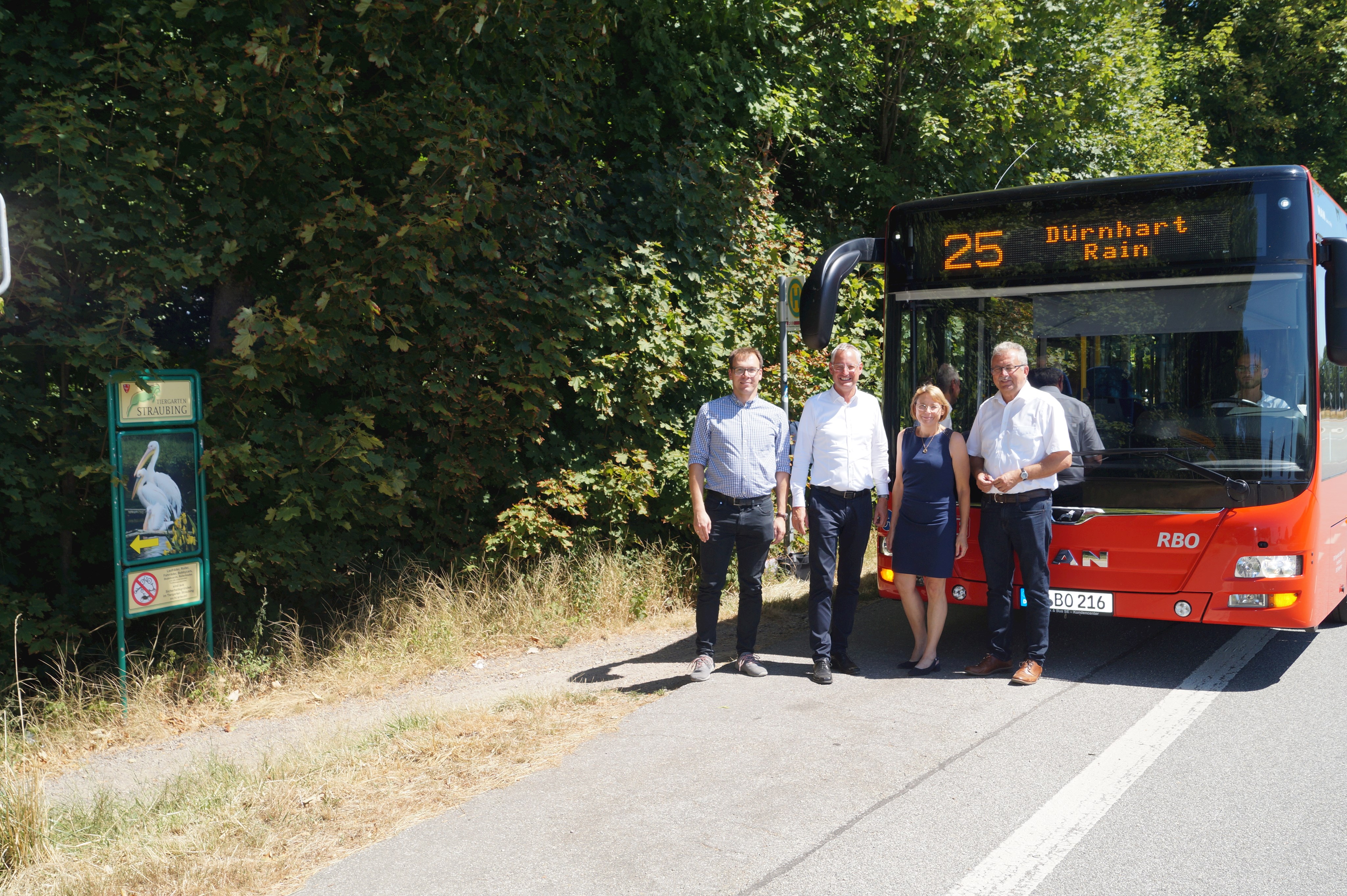 Philipp Pietsch (RBO), Oberbürgermeister Markus Pannermayr, Brigitte Tschimmel (Landratsamt) und Landrat Josef Laumer (von links) stehen an der Haltestelle Tiergarten der VSL-Linie 25. Im Hintergrund ein Bus der Linie 25.