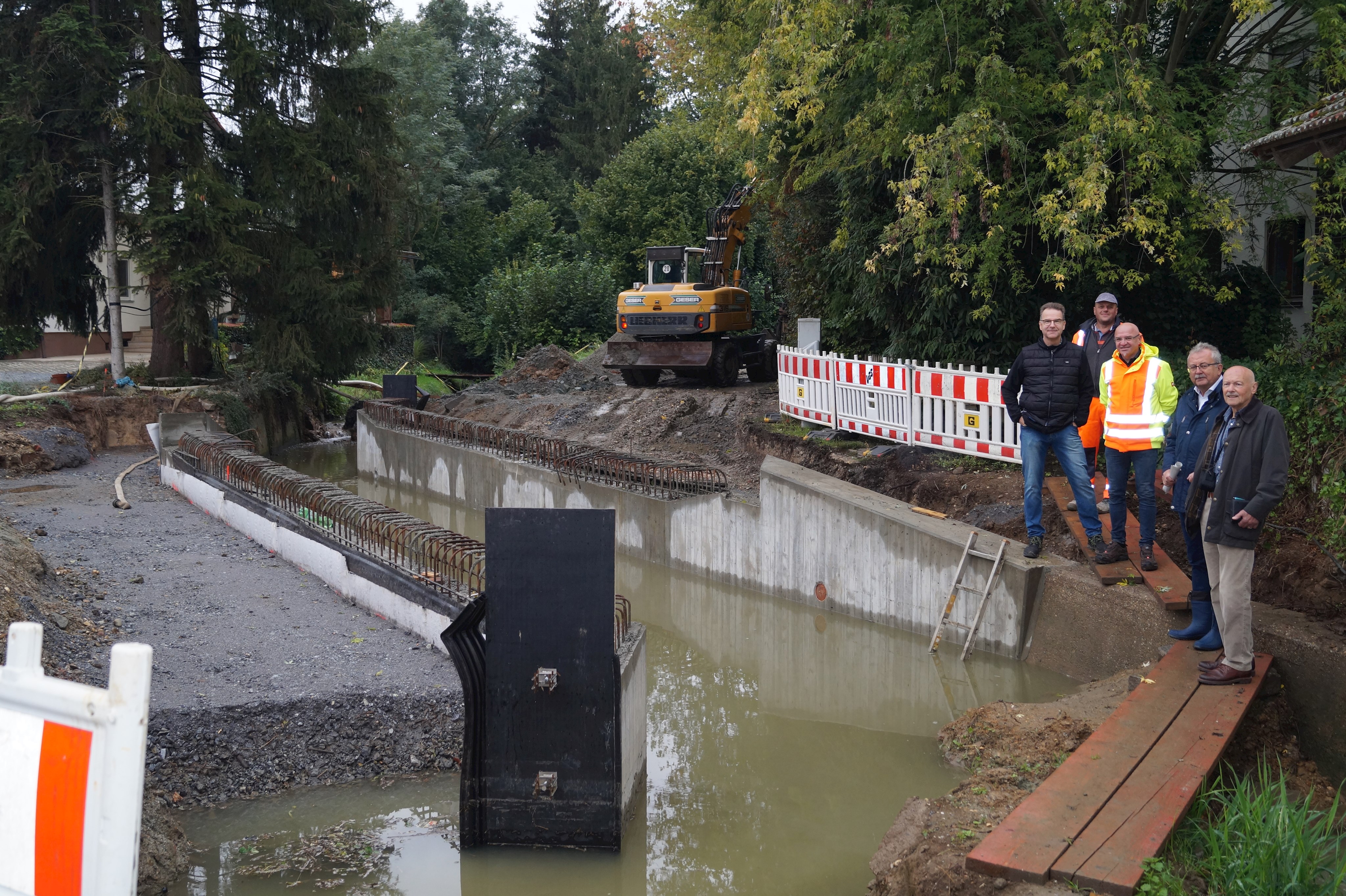 Peter Knijnenburg (IB K + U Plan), Landrat Josef Laumer, Markus Fischer (Leiter Tiefbauverwaltung) und Stefan Strauss (Firma Guggenberger, von vorne rechts) stehen beim Ortstermin an der Brückenbaustelle.