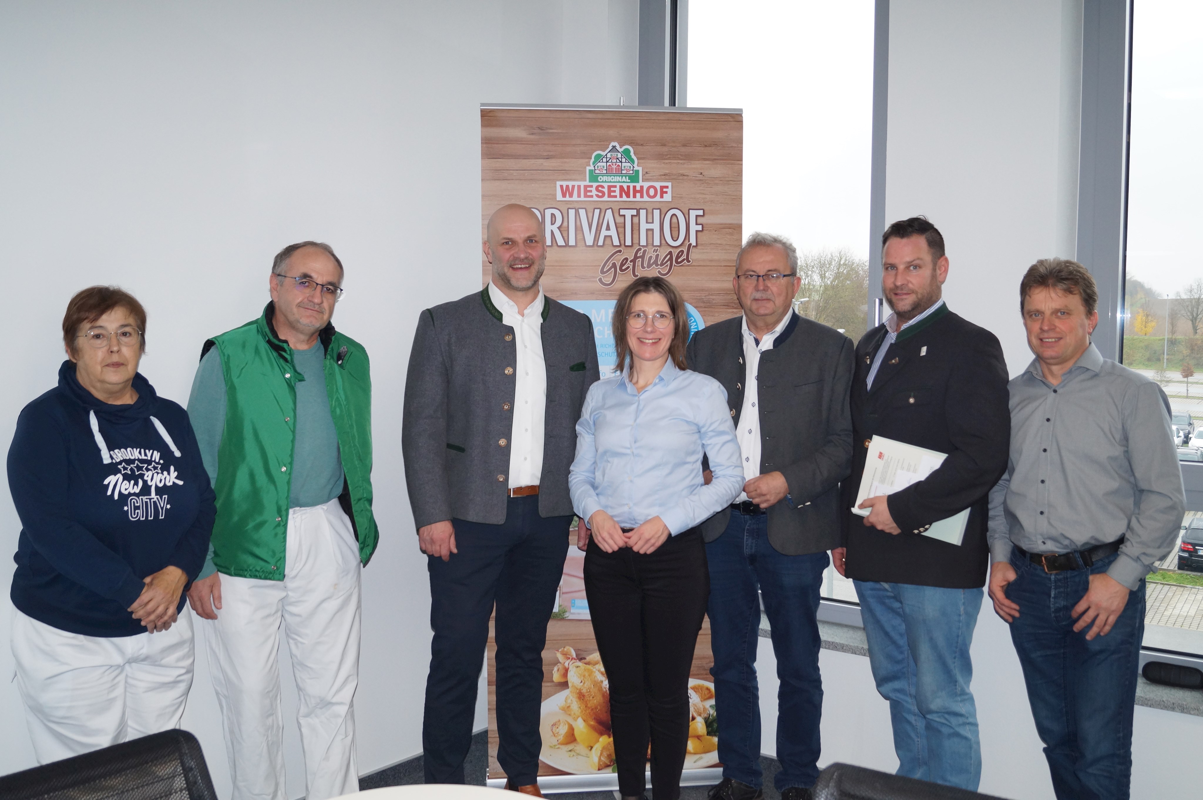 Dr. Marina Sachenbacher (Leiterin Sachgruppe Geflügelbeschau), Martin Sansoni (Leiter Veterinäramt), Simon Blank (Geschäftsleiter Donautal), Andrea Probst (Bürgermeisterin Bogen), Landrat Josef Laumer, Martin Köck (Wirtschaftsreferent) und Josef Kräh (Betriebsratsvorsitzender Donautal, von links) stehen in einem Besprechungszimmer der Firma Donautal.