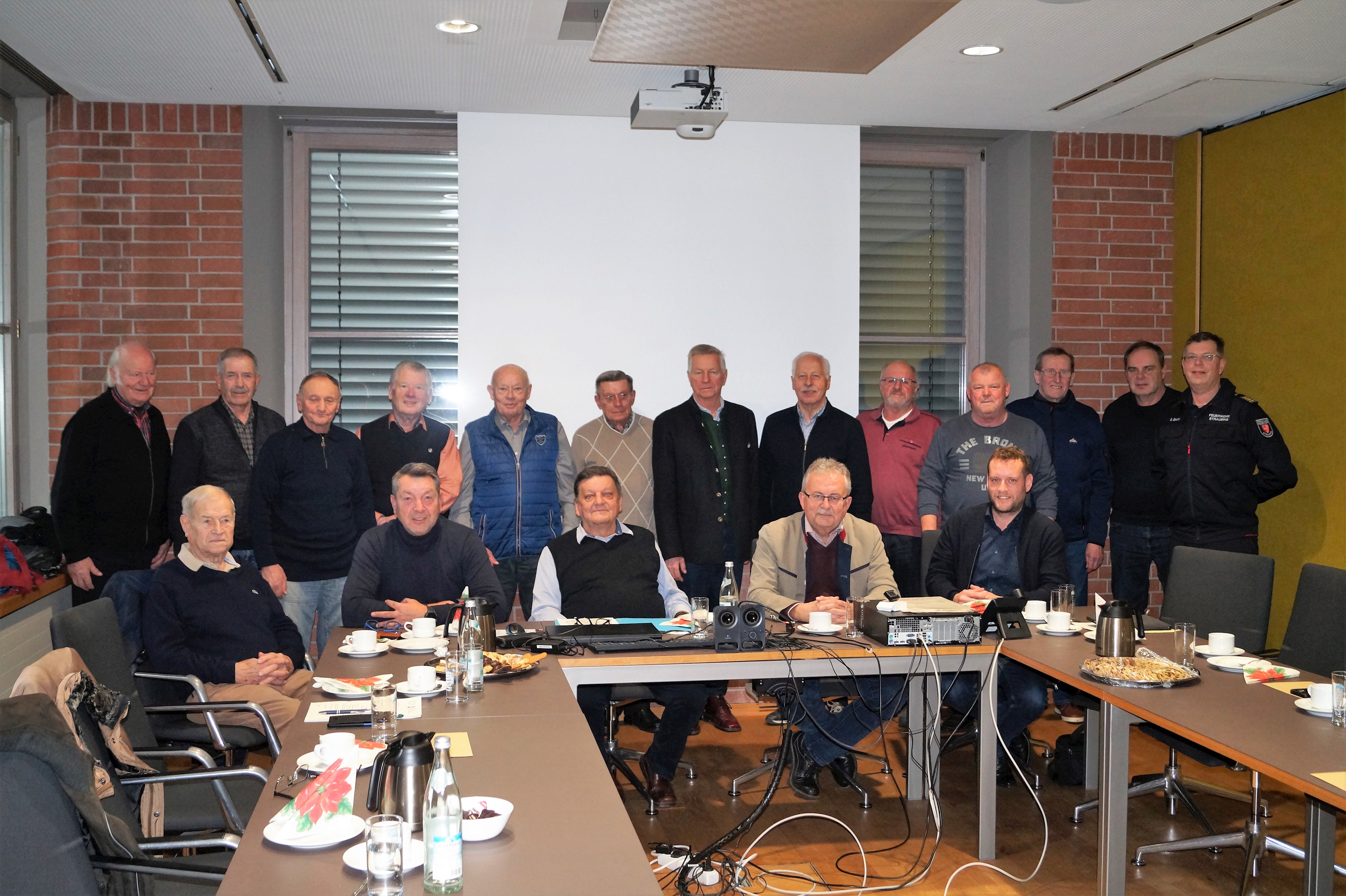 Die ehemaligen Führungskräfte der Landkreisfeuerwehren bei ihrem Treffen im Landratsamt im Kleinen Sitzungssaal gemeinsam mit Landrat Josef Laumer (sitzend, 2. von rechts), Kreisbrandrat Albert Uttendorfer (sitzend, 2. von links) und Stadtbrandrat Stephan Bachl (stehend ganz rechts).