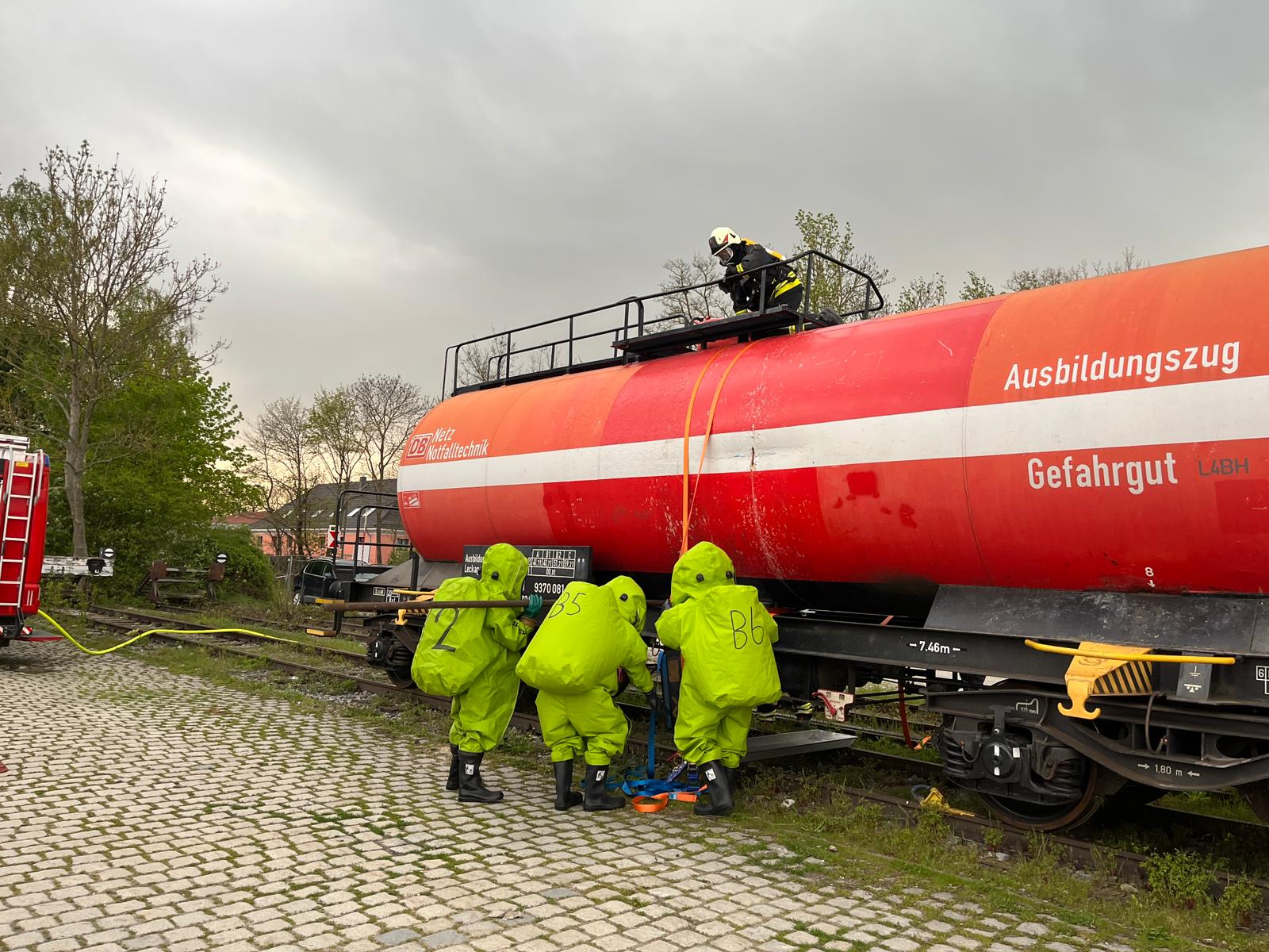 Die Feuerwehrler in Schutzausrüstung beim Training am Ausbildungszug der Deutschen Bahn.