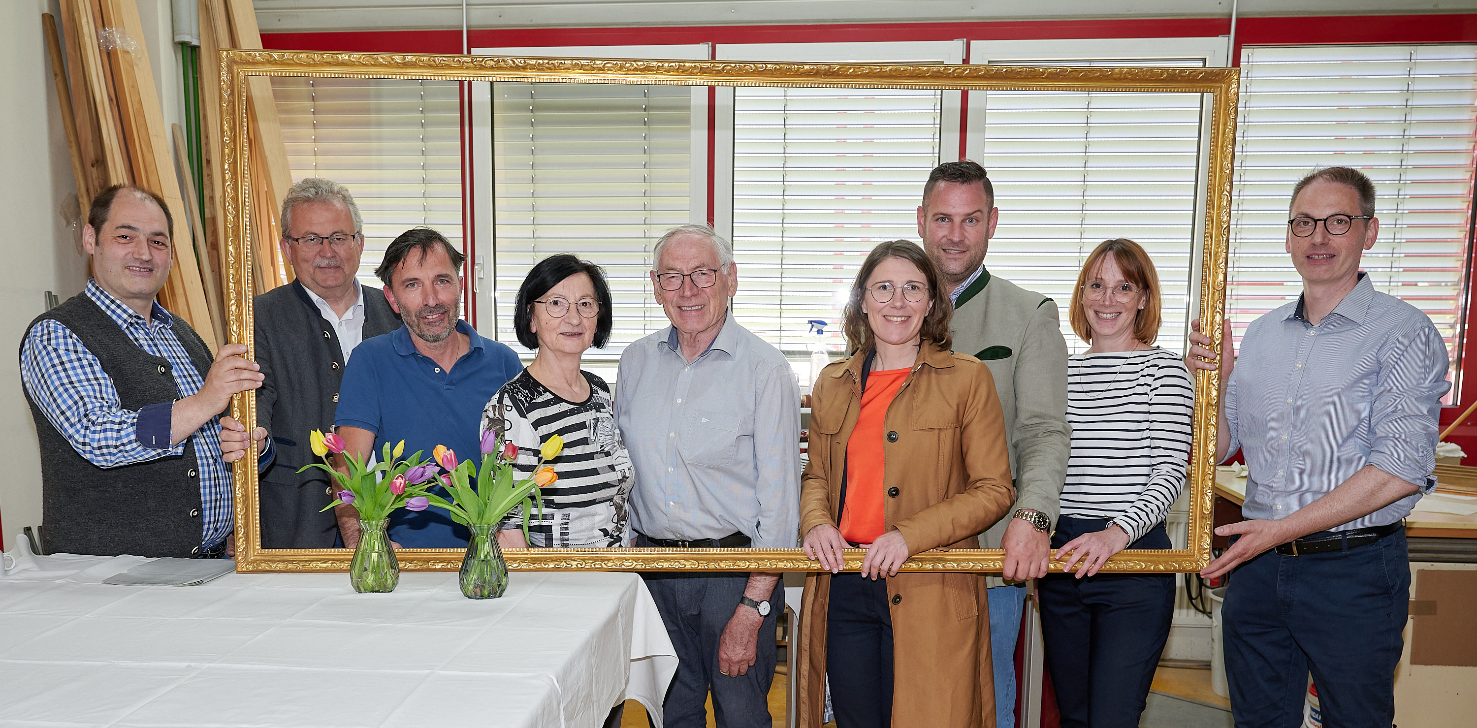 Andreas Mittermeier, Landrat Josef Laumer, ein Mitarbeiter der Firma, Anton Mittermeier mit Ehefrau, Bürgermeisterin Andrea Probst, Wirtschaftsreferent Martin Köck und Armin Mittermeier mit Ehefrau (von links) nach dem Rundgang durch die Firmenräume beim Foto in einem überdimensionalen Rahmen der Firma.