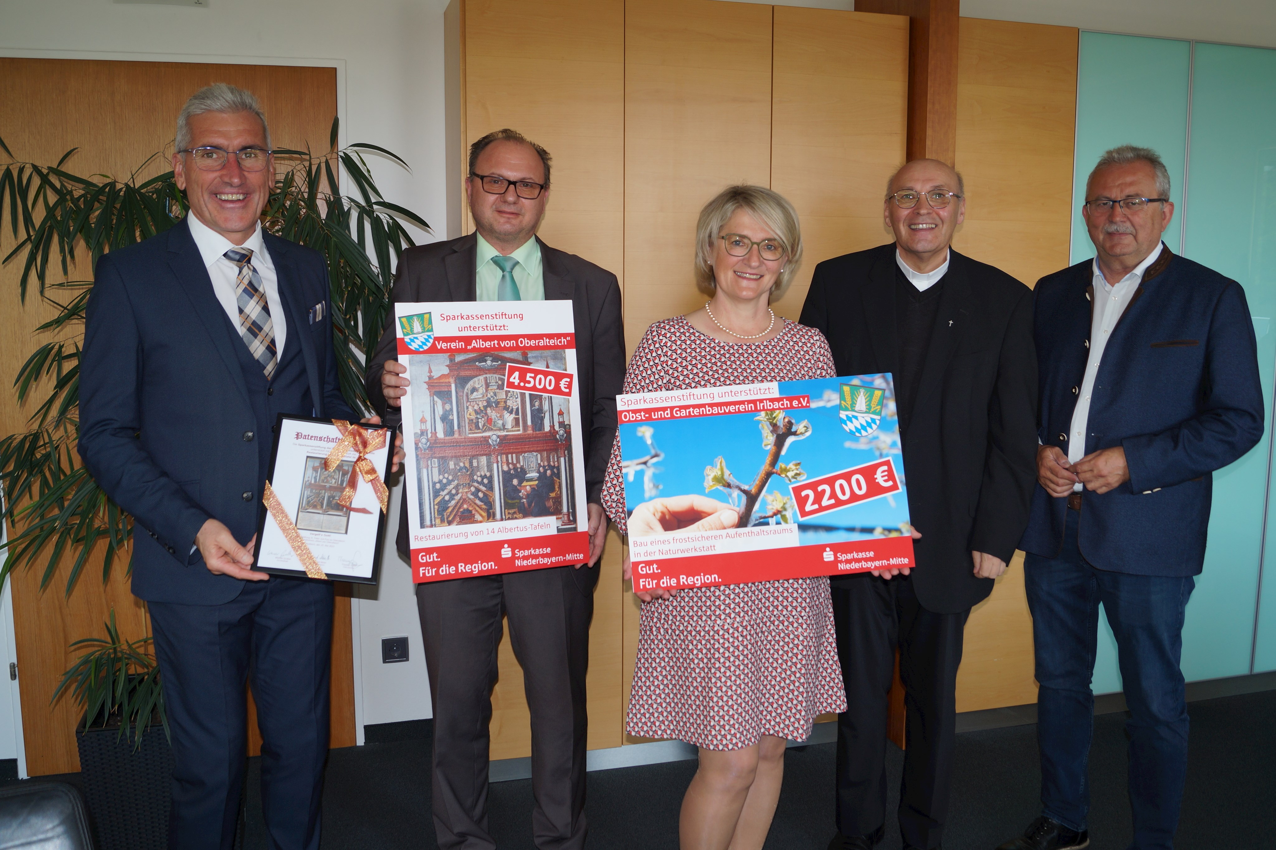 Vorstandsvorsitzender Walter Strohmaier (mit Patenschaftsurkunde in der Hand), Thomas Saller (Freundeskreis „Albert von Oberalteich“), Regina Staudinger (Vorsitzende OGV Irlbach), Pfarrer Richard Meier (Oberalteich) und Landrat Josef Laumer (von links) stehen bei der Spendenübergabe im Büro des Landrats.