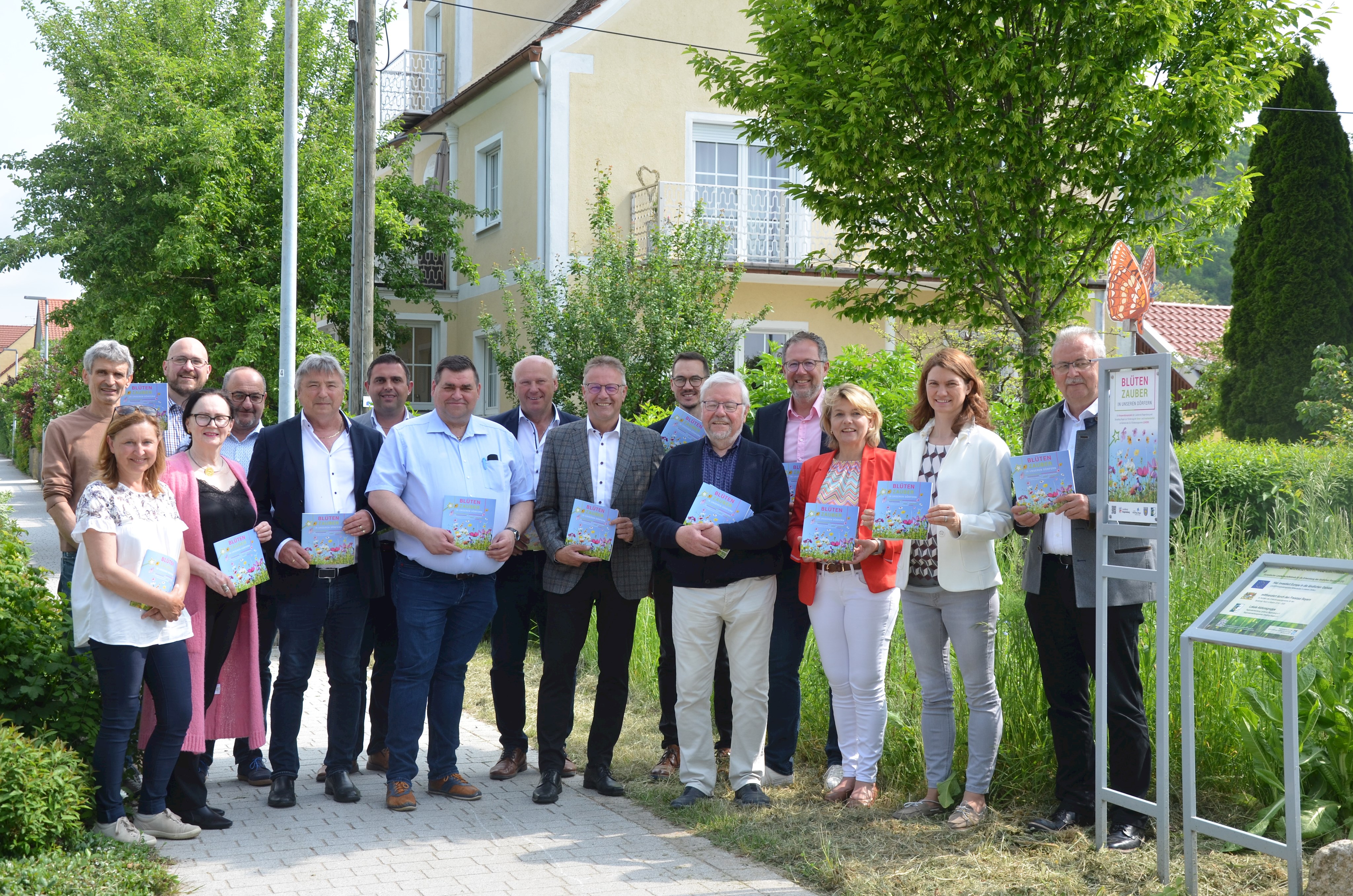 Die Teilnehmerinnen und Teilnehmer der Veranstaltung stehen vor der Blühwiese beim Gruppenfoto.