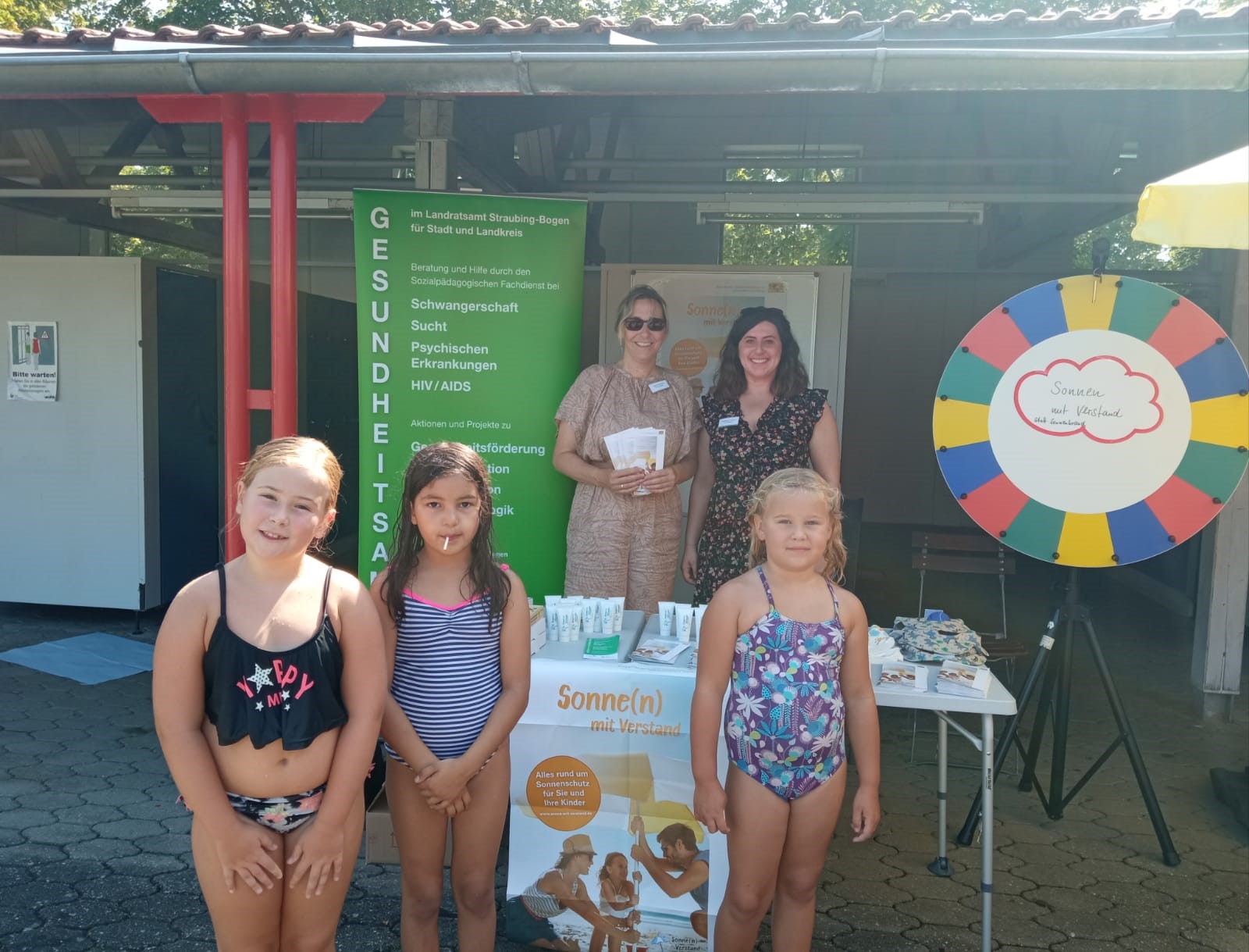 Die Sozialpädagoginnen Alexandra Jehle und Verena Reitberger mit jugendlichen Badegästen am Infostand.