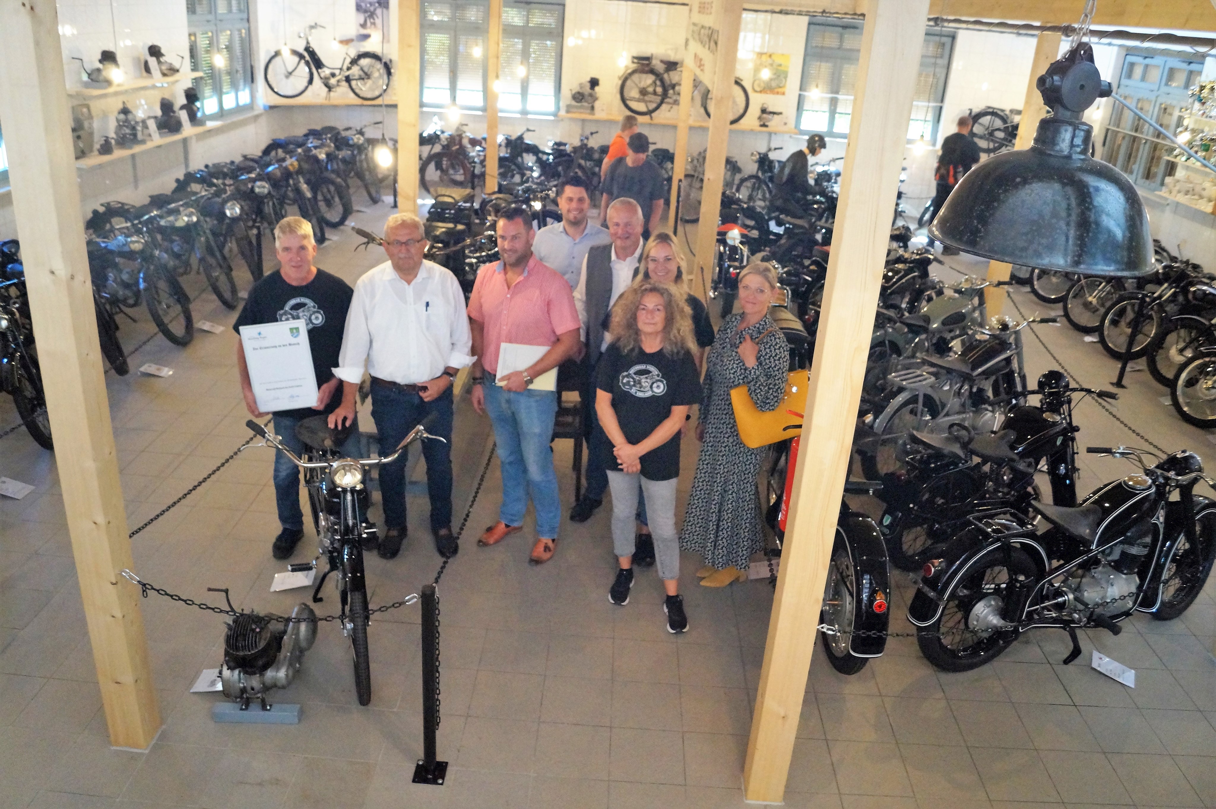 Die Besucher stehen in einem Ausstellungsraum des Motorradmuseums vor den Exponaten