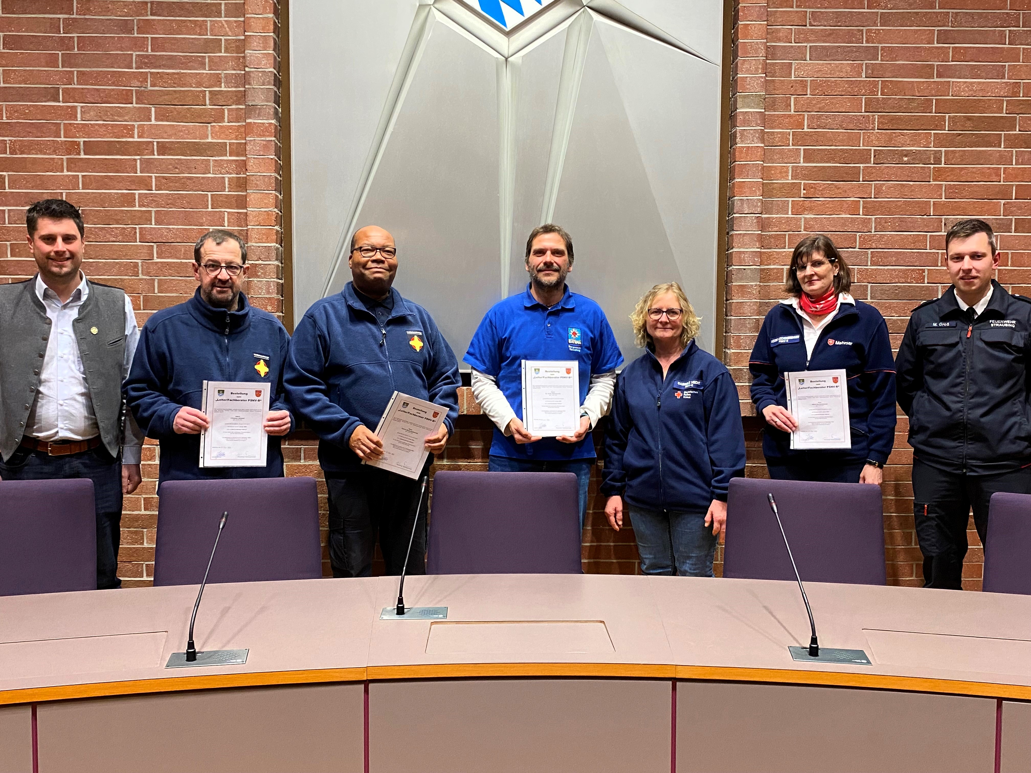 Stellvertretender Landrat Andreas Aichinger, Leiter PSNV/Fachberater PSNV Christian Schmid, Leiter PSNV/Fachberater PSNV Pfarrer Patrice Banza-Kabwende, Leiter PSNV/Fachberater PSNV und Sprecher der ARGE Dr. Andre Müllerschön, Stellvertretende Sprecherin der ARGE Gabriele Hecht, Leiterin PSNV/Fachberaterin PSNV Astrid Aschenbrenner, Michael Groß (Stellvertretender Leiter Amt für Katastrophenschutz der Stadt Straubing) im Sitzungssaal des Landratsamtes.