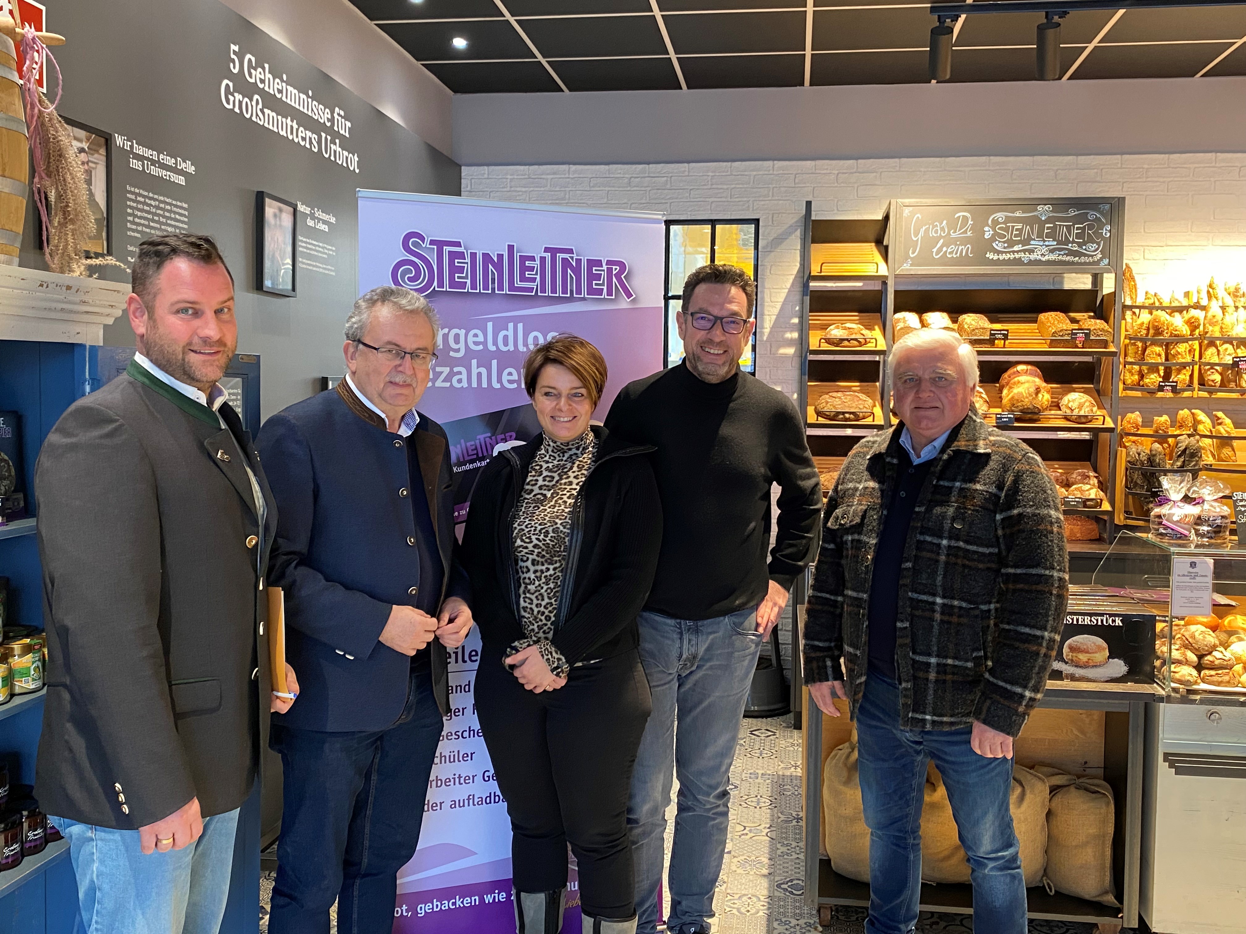 Wirtschaftsreferent Martin Köck, Landrat Josef Laumer, Stefanie und Markus Steinleitner und Bürgermeister Ludwig Waas stehen im Verkaufsraum der Bäckerei in Niederwinkling.