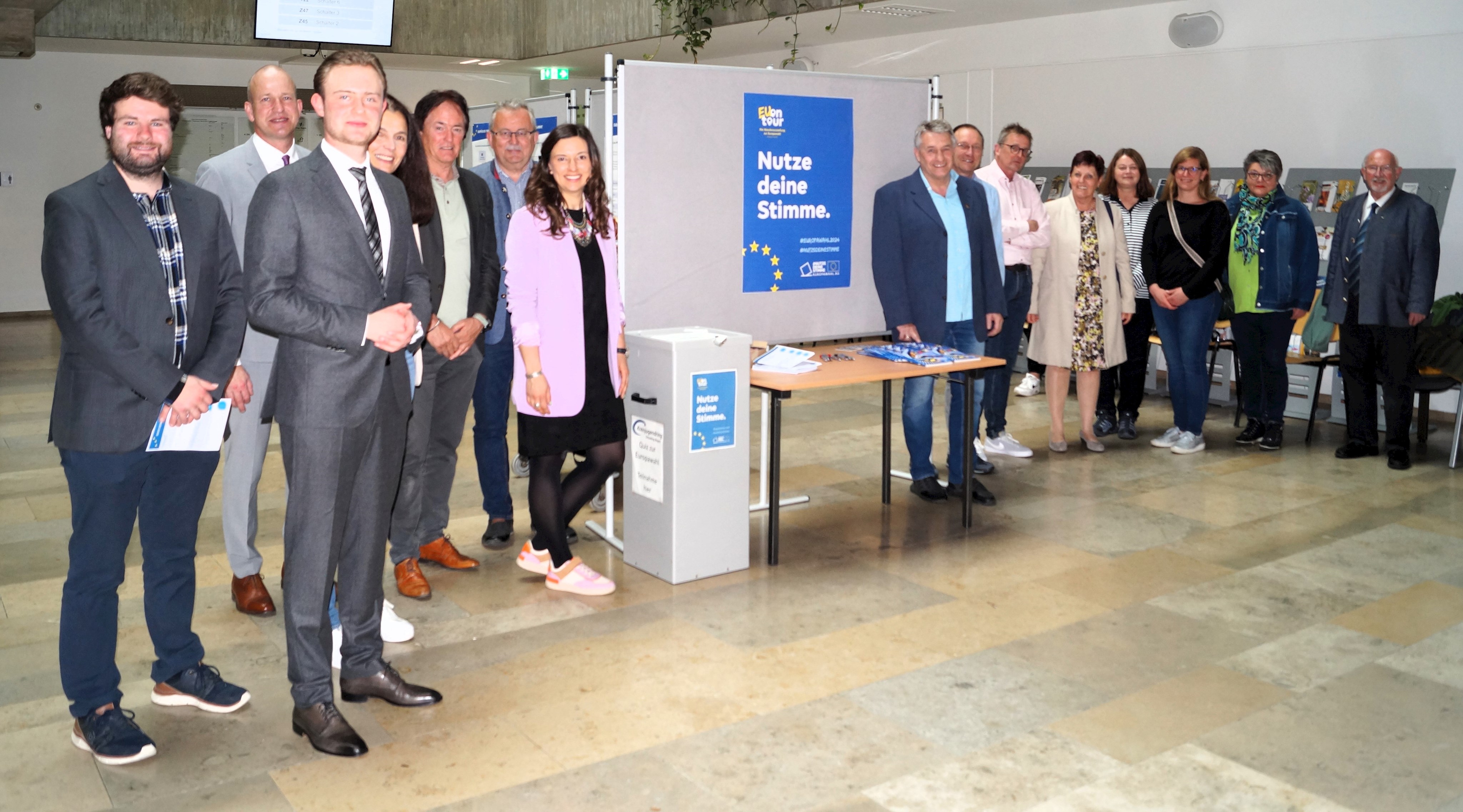 Die Gäste bei der Ausstellungseröffnung stehen im Foyer des Landratsamtes vor den Ausstellungstafeln.