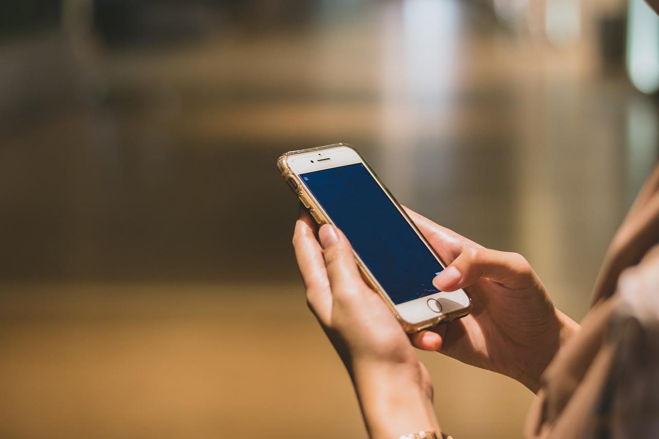 Symbolbild einer Person mit Handy in der Hand