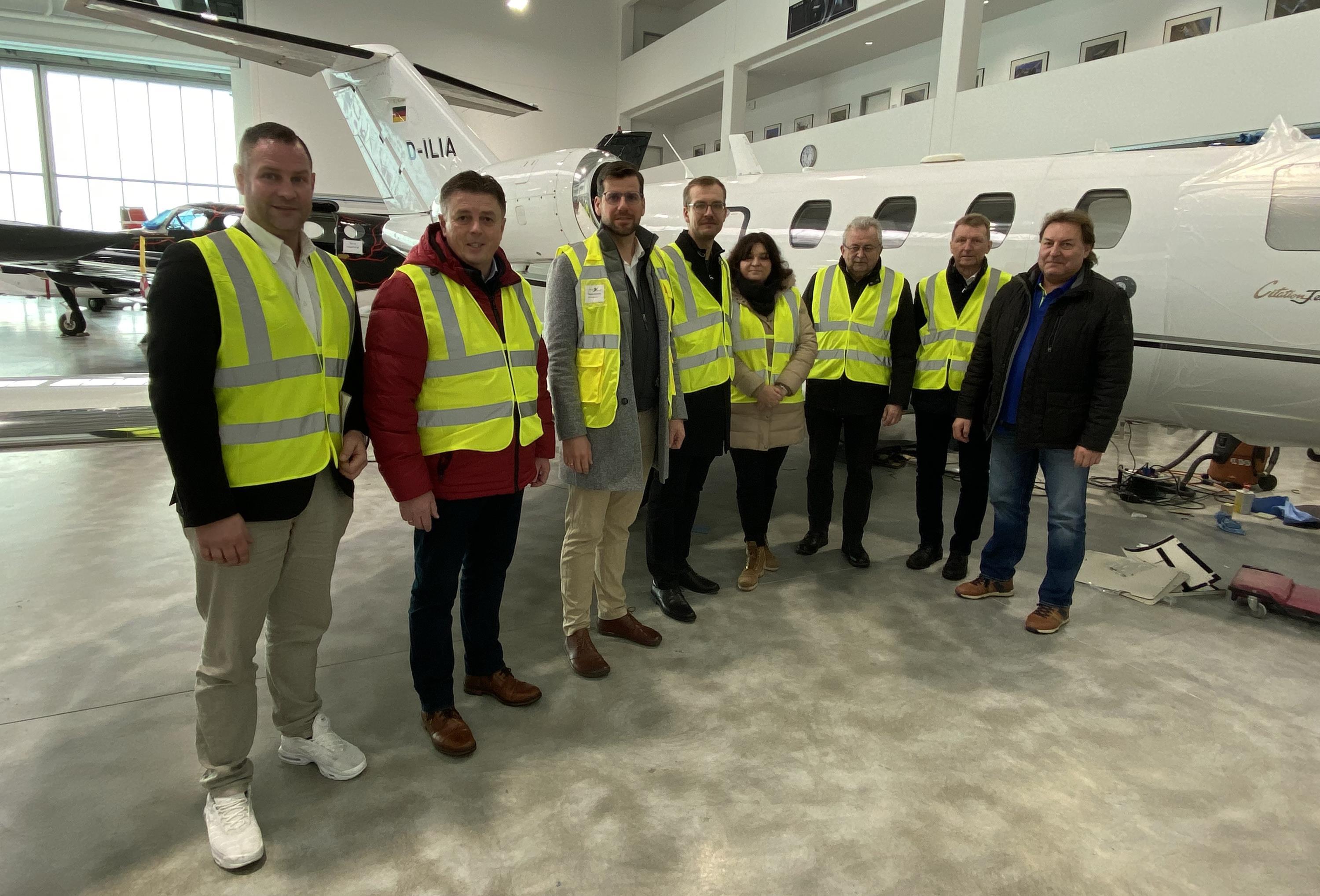 Die Gäste zu Besuch in der Halle der Firma Avionik vor einem Flugzeug