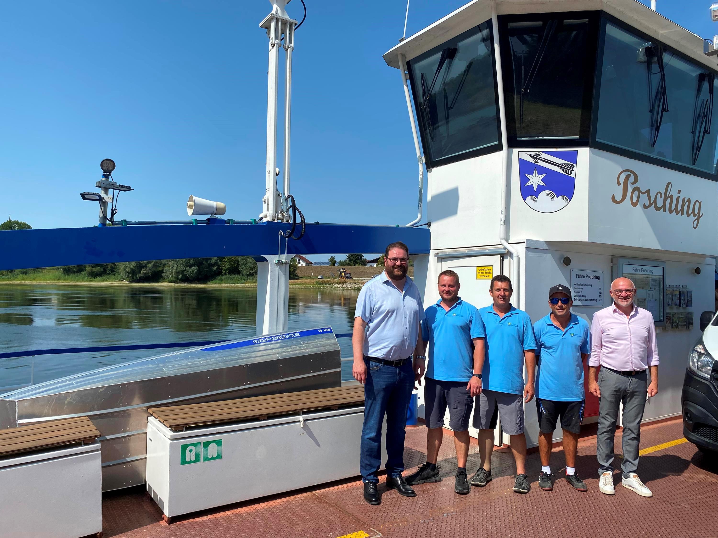 Gruppenfoto auf der Fähre mit Blick auf das Ufer von Mariaposching
