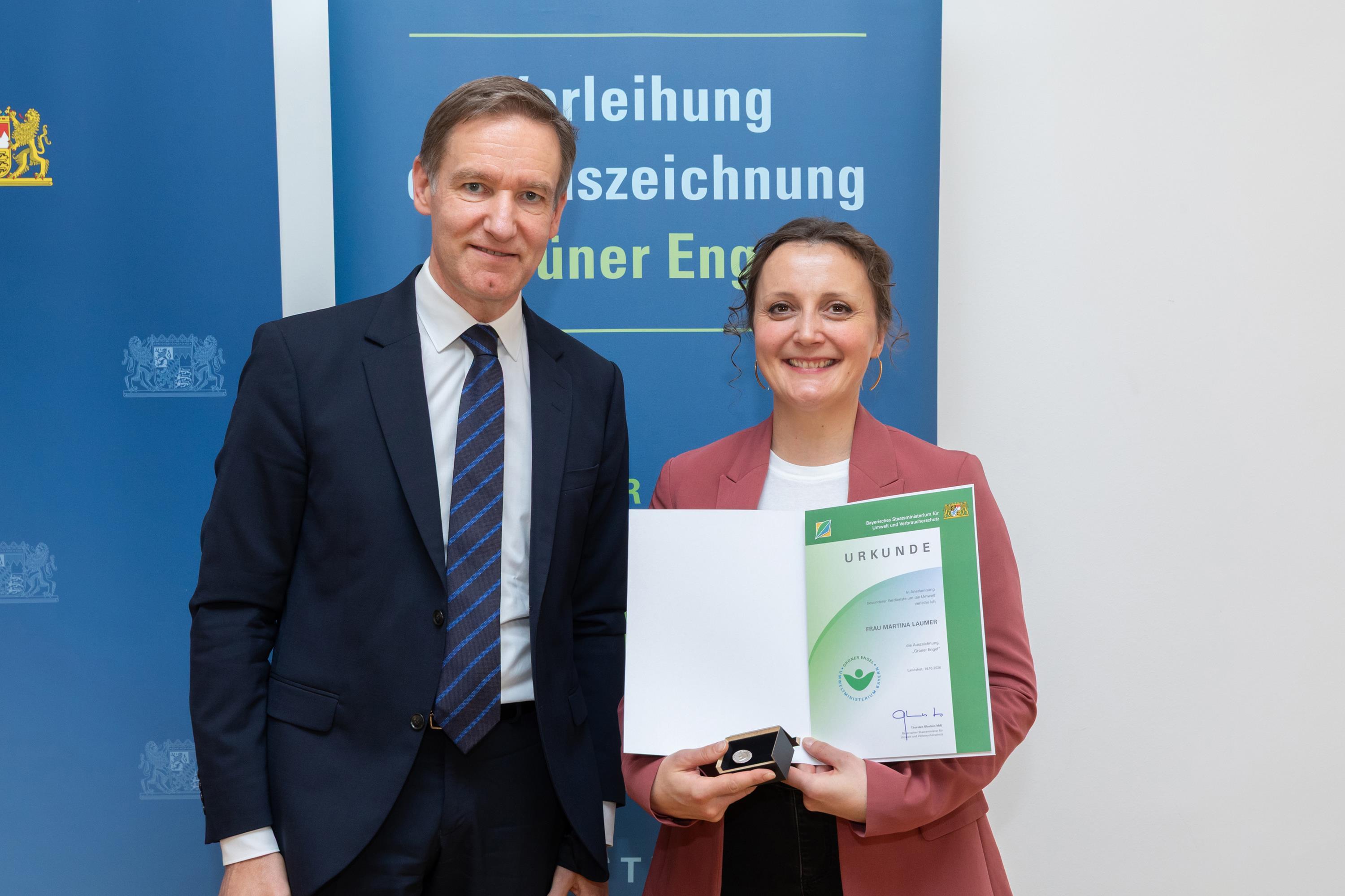 Der Regierungspräsident überreicht Martina Laumer die Urkunde