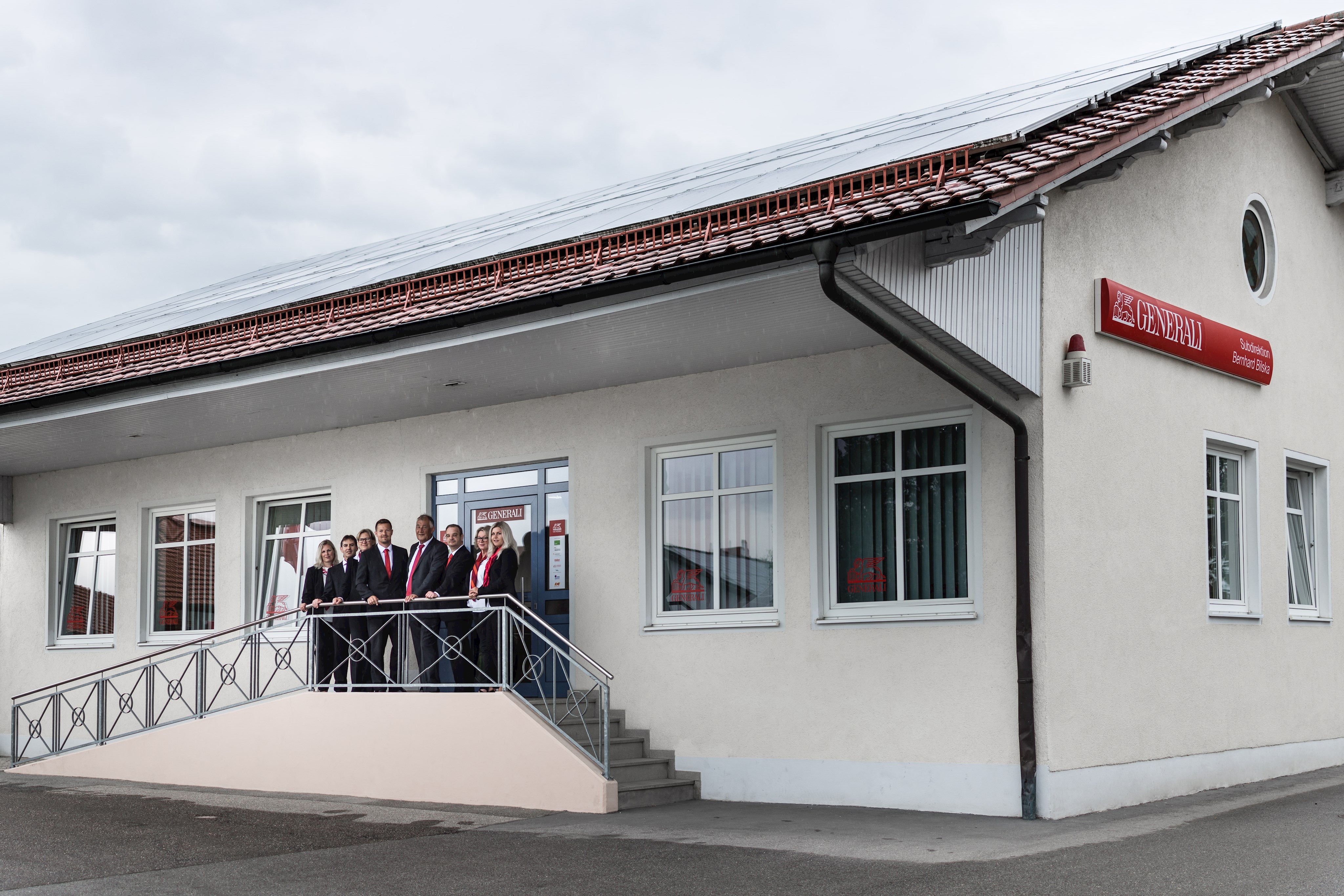 Zu sehen sind die Mitarbeiter der Versicherungsagentur Generali Bilska auf der Treppe vor dem Firmengebäude.