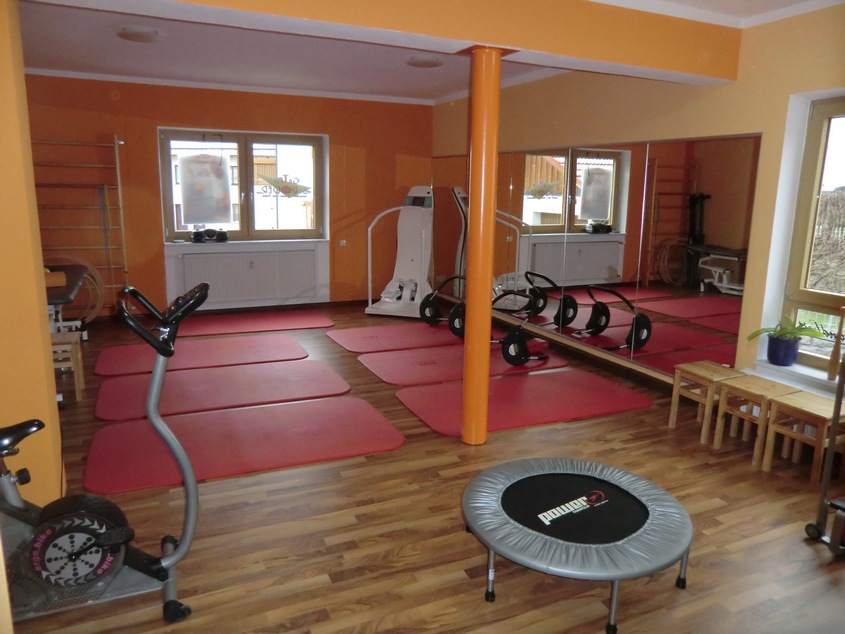Im hinteren Teil des Raumes liegen Gymnastikmatten. An der Rechten Wand sind Spiegel angebracht, davor liegen Geräte zum Training der Bauchmuskulatur.
Im Vordergrund steht links ein Ergometer und rechts ein Trampolin.