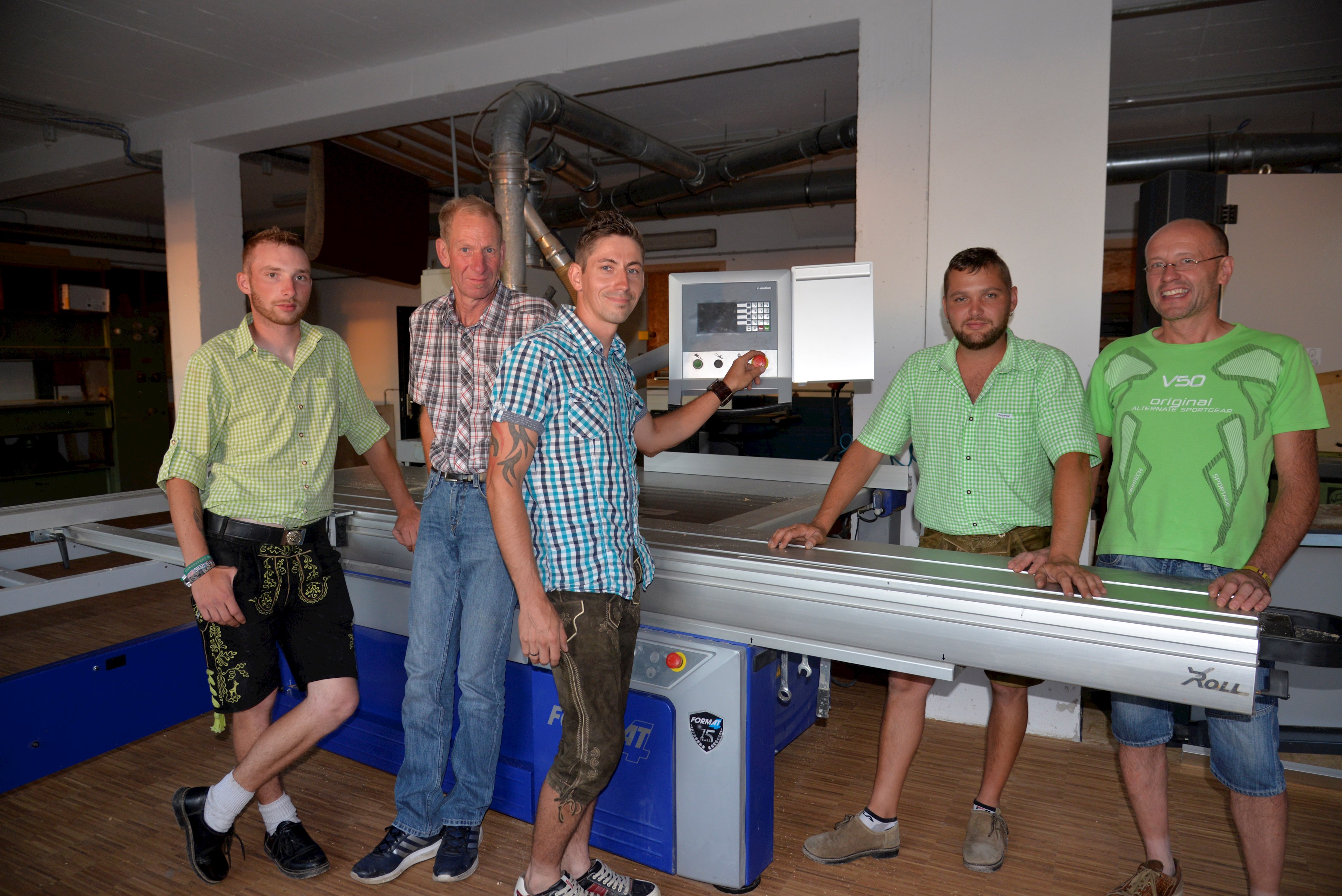 Gruppenbild Ludwig Mach GmbH, alle Mitarbeiter stehen vor eine CNC-Fräse