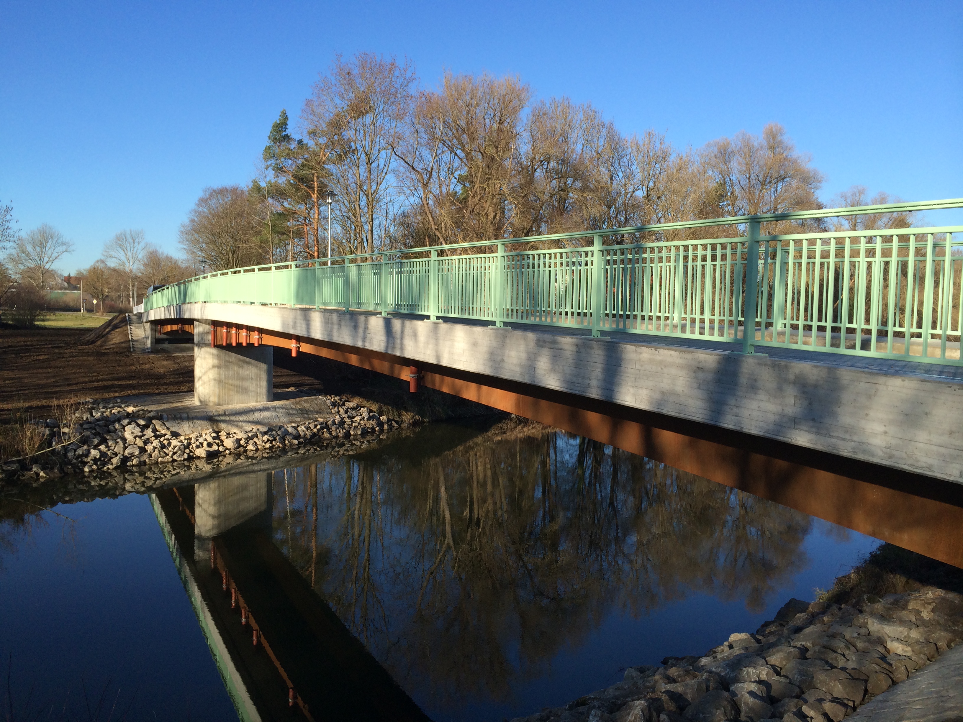 Zu sehen ist eine Brücke über einen Fluss, welche von der Firma Fahrner errichtet wurde.