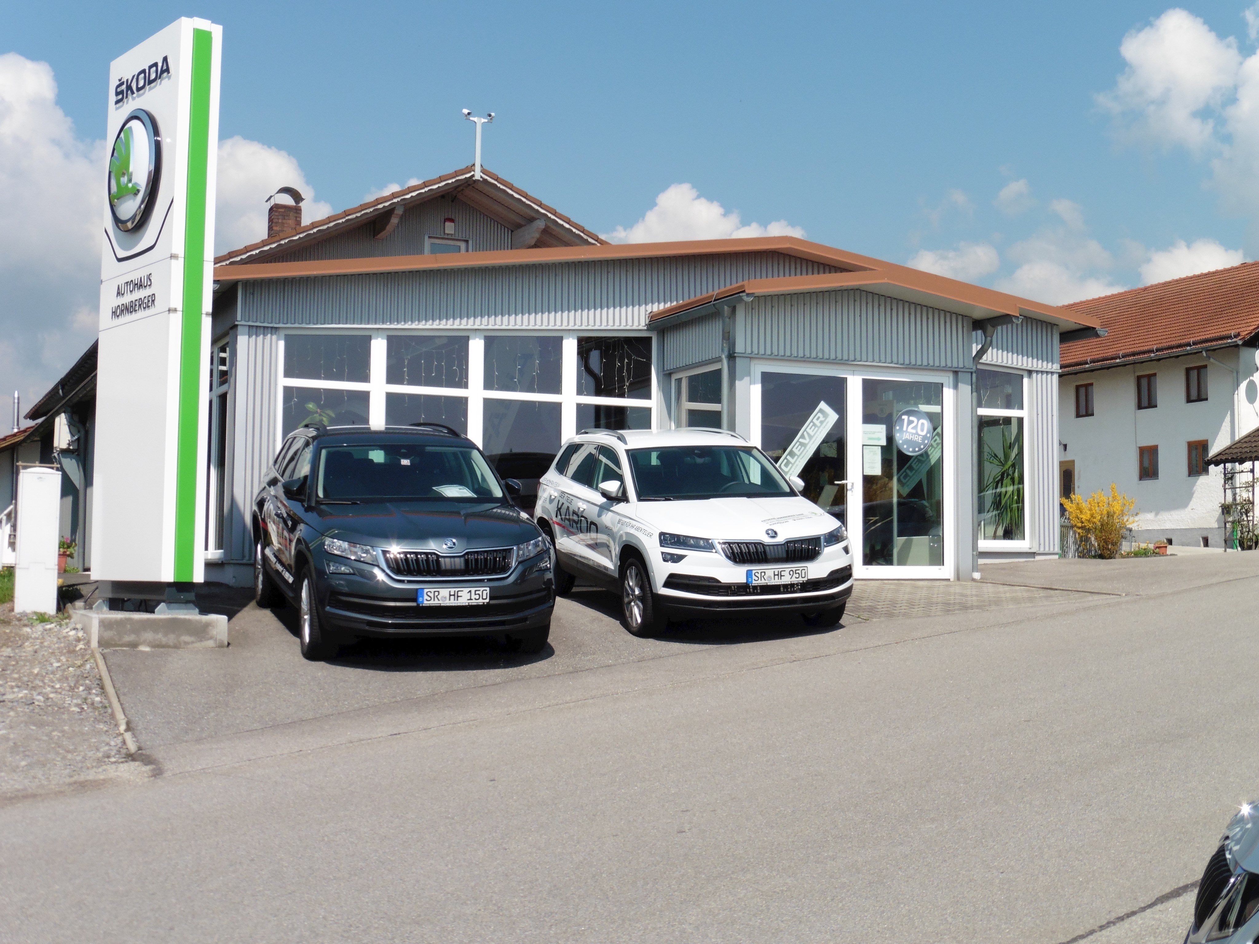 Betriebsgebäude Autohaus Hornberger mit zwei PKWs der Mark SKODA im Vordergrund