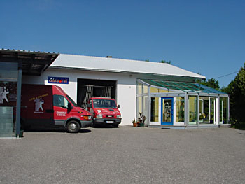 Betriebsgebäude Glaserei Liebl mit zwei Firmenfahrzeugen auf der linken Seite und dem Eingang auf der rechten Seite.