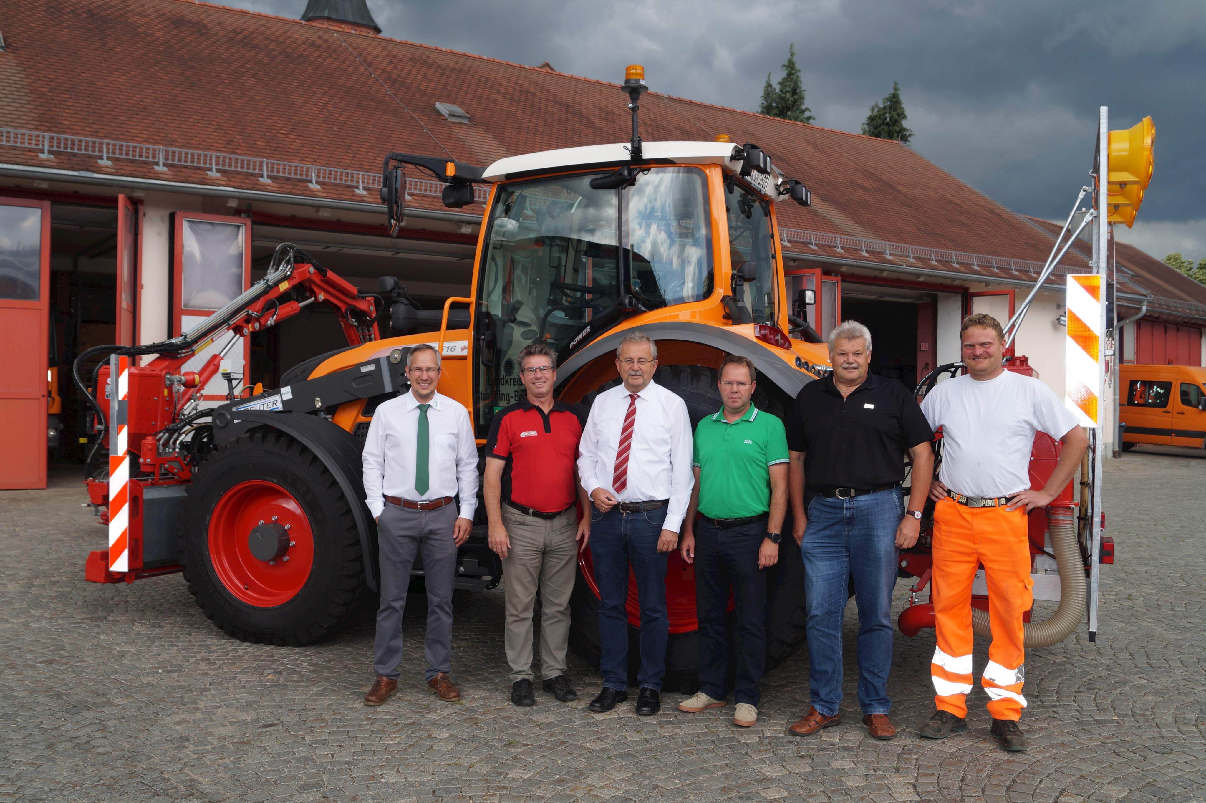 Karlheinz Besenreiter (BayWa AG Straubing), Karl Fleischer (Firma Dücker), Landrat Josef Laumer, Armin Winter (Stellvertretender Leiter der Tiefbauverwaltung), Eugen Schedlbauer (Leiter Bauhof Ittling) und Fahrzeugführer Andreas Kainz (von links) bei der Übergabe des neuen Mähtraktors im Hof des Bauhofs Ittling.