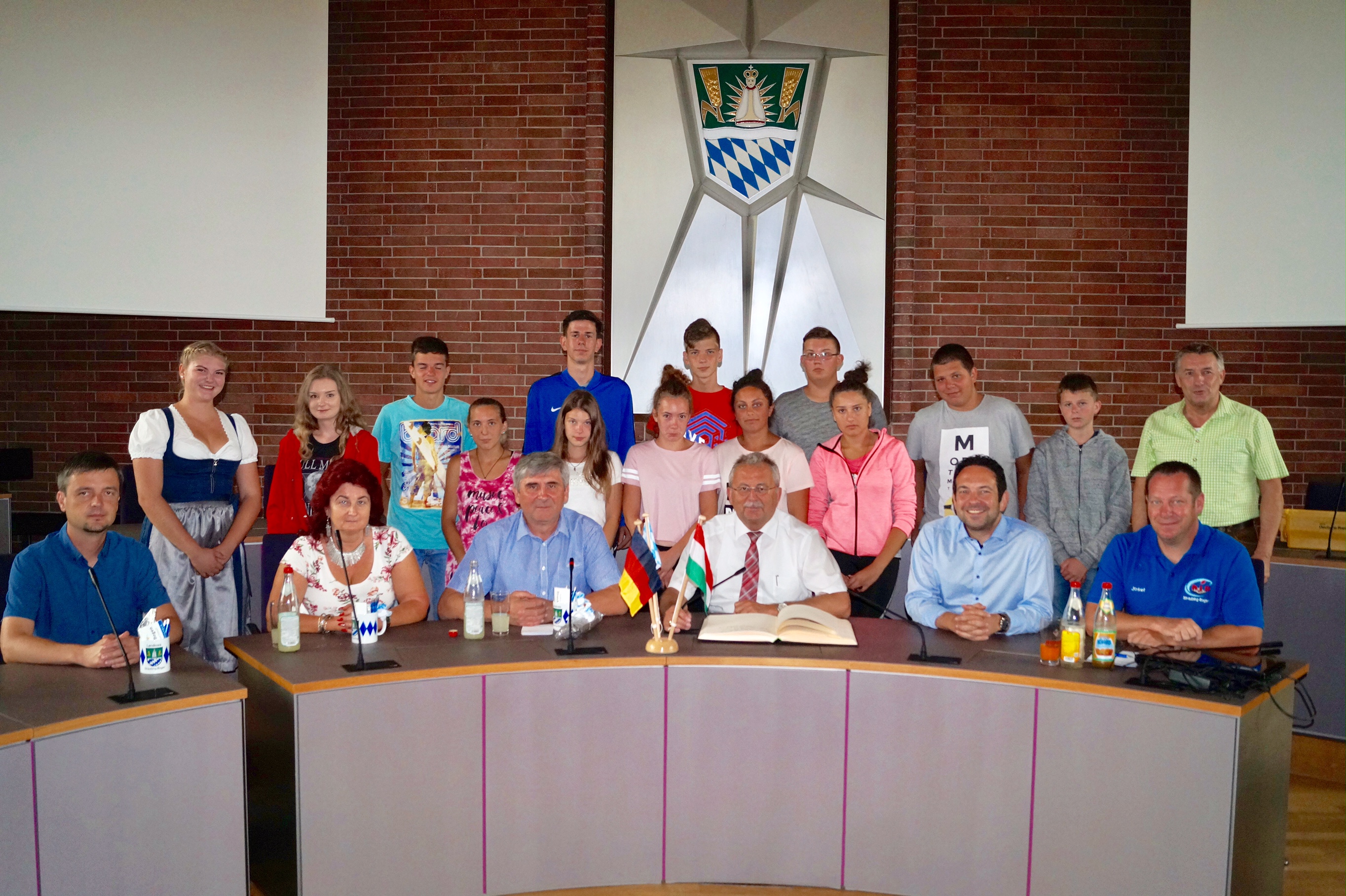 Foto: Die ungarische Schülergruppe mit ihren drei Begleitungen (sitzend, vorne von links), Landrat Josef Laumer (sitzend, dritter von rechts), Robert Dollmann (Vorsitzender des KJR, sitzend, zweiter von rechts) und KJR-Vorstandsmitglied Josef Solleder (sitzend, ganz rechts) im Großen Sitzungssaal des Landratsamtes Straubing-Bogen. Stehend ganz rechts Kreisjugendpfleger Richard Maier.