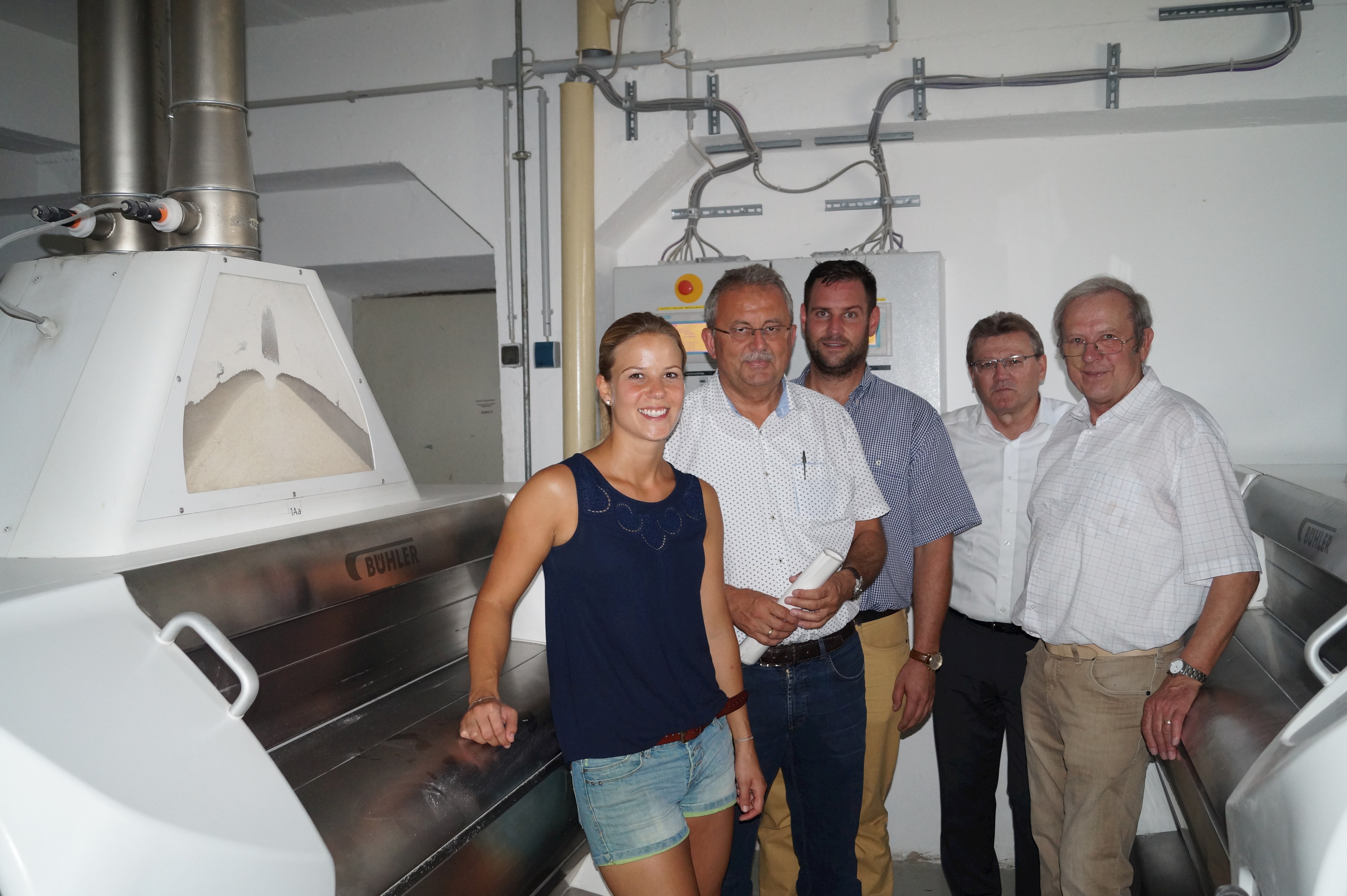 Susanne Dorfner mit den Gästen Landrat Josef Laumer, Wirtschaftsreferent Martin Köck, Klaus Achatz (Sachgebietsleiter Wirtschaft am Landratsamt) und Hans Agsteiner (2. Bürgermeister der Gemeinde Steinach, von links) in der Mühle vor den vollautomatisierten Geräten.