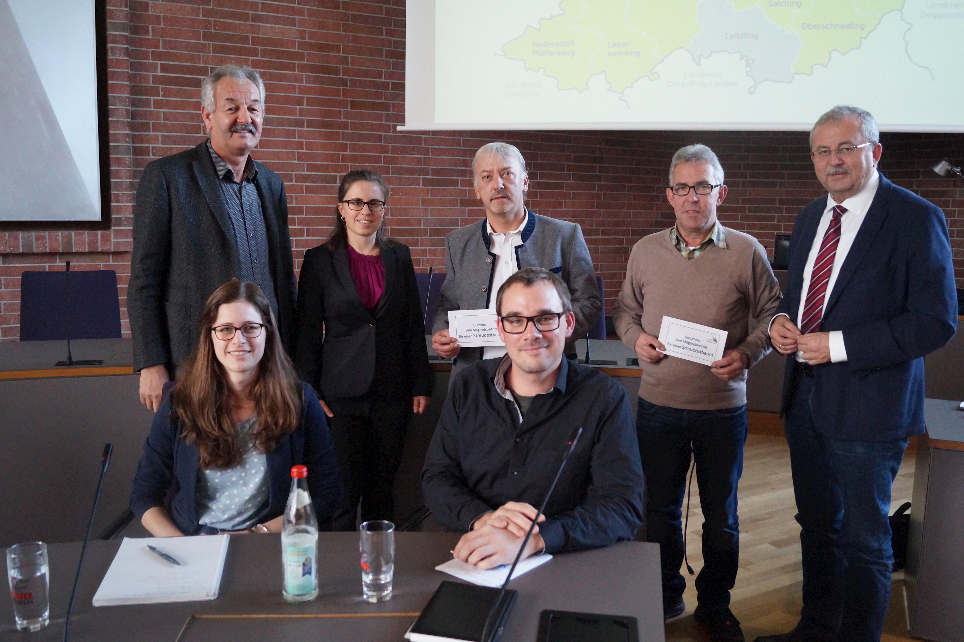 Landrat Josef Laumer begrüßt die neuen LPV-Mitglieder Geiselhöring (Franz Winter) und Perasdorf (Thomas Schuster) gemeinsam mit LPV-Geschäftsführerin Julia Hagner und dem Stellvertretenden LPV-Vorsitzenden Gerhard Stadler (hinten stehend von rechts). Vorne sitzend Julia Schnurrer und Ambros Köppl.