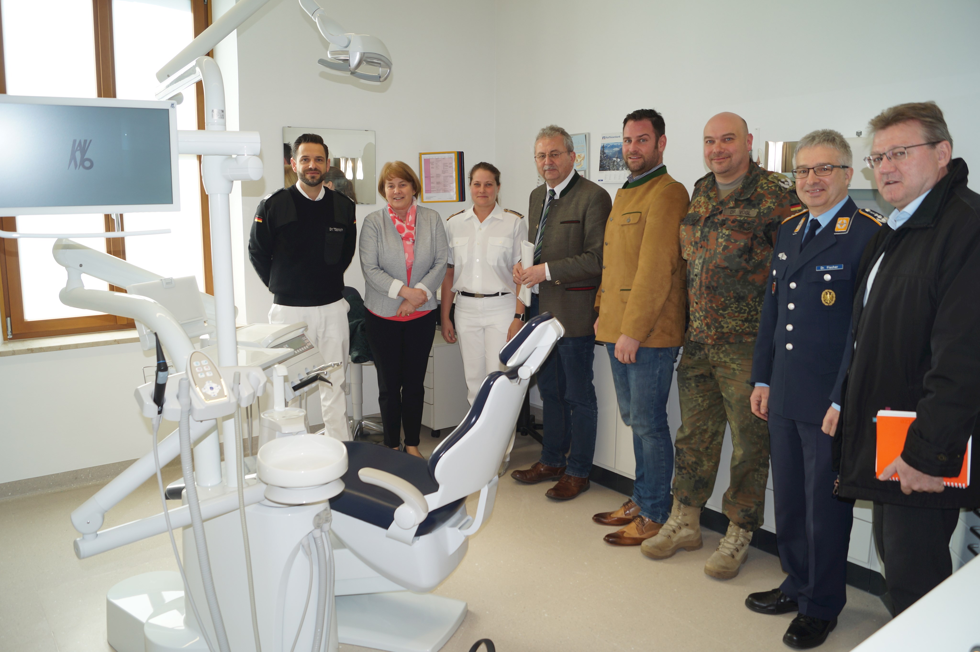 Oberfeldarzt Dr. Robert Töpsch, Stellvertretende Landrätin Barbara Unger, Hauptfeldwebel Nicole Färber, Landrat Josef Laumer, Wirtschaftsreferent Martin Köck, Oberfeldarzt Dr. Roland Vogl, Oberstabsarzt Dr. Harald Fischer und Sachgebietsleiter Klaus Achatz (Sachgebiet Wirtschaft/Touristik/Kreisentwicklung am Landratsamt Straubing-Bogen, von links) stehen bei der Besichtigung in der Gäubodenkaserne im zahnärztlichen Bereich um den Patientenstuhl.