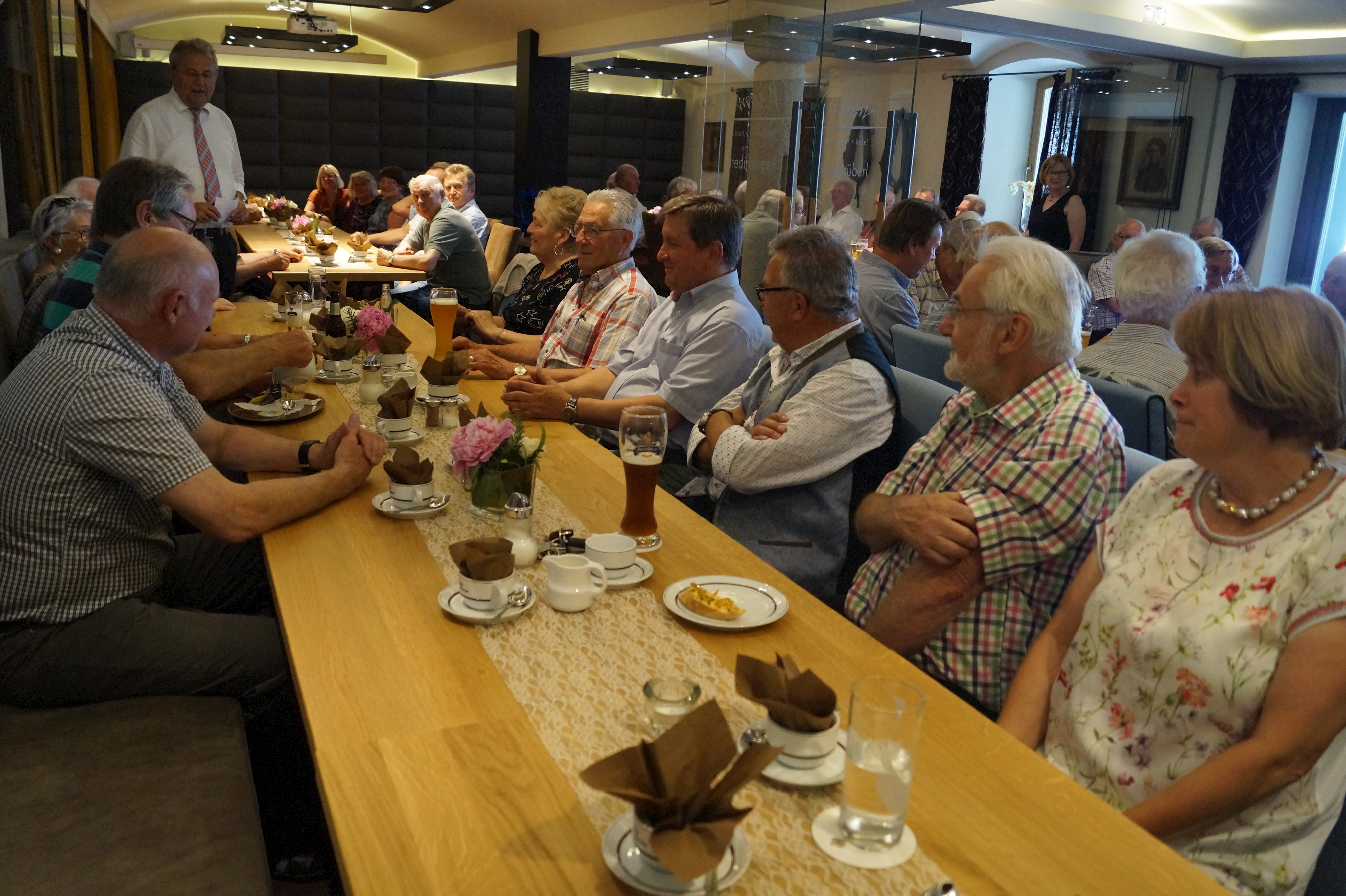 Die Ehemaligen lauschen im Gastraum der Rede von Landrat Josef Laumer.