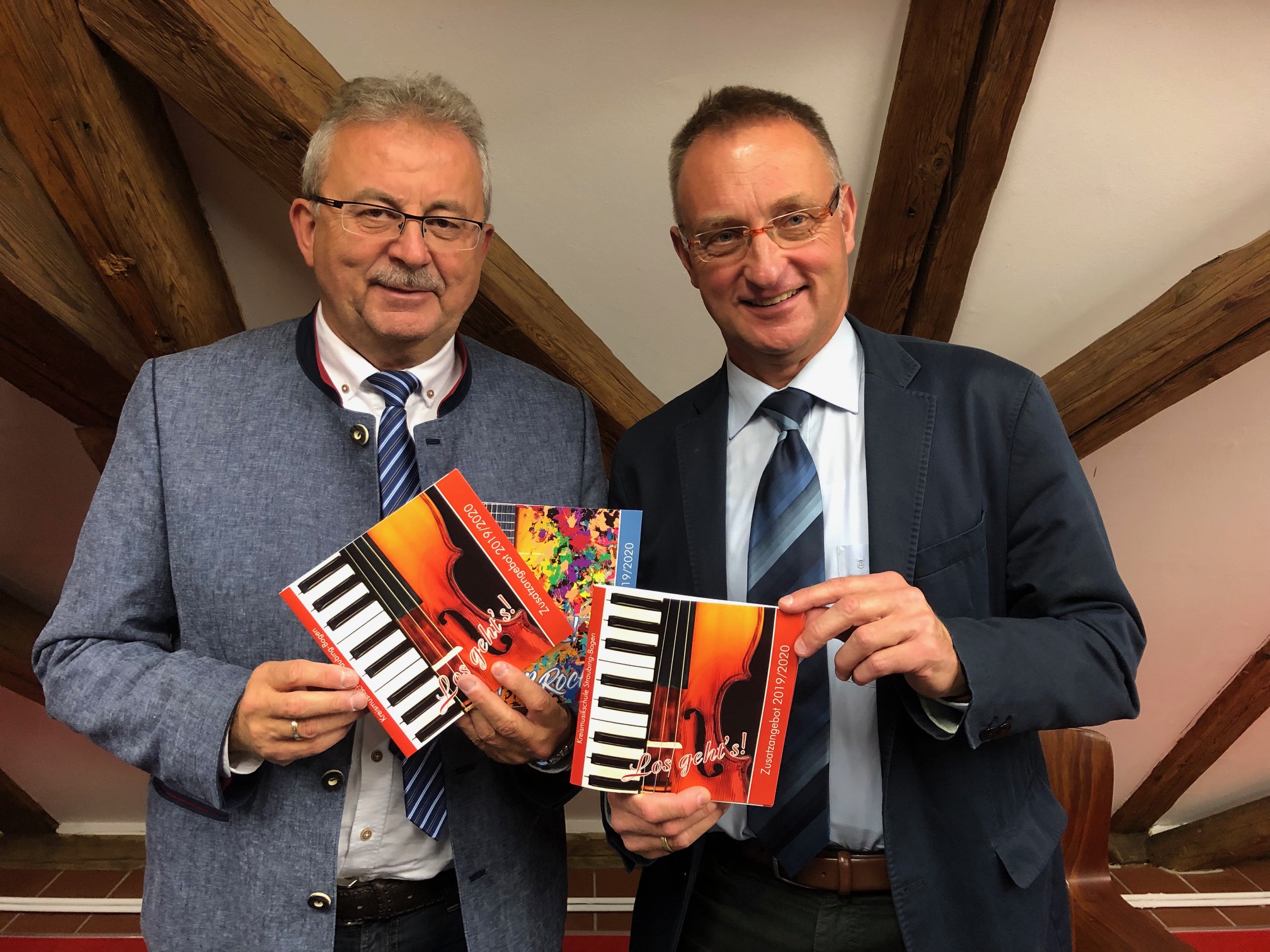 Foto: Landrat Josef Laumer (links) und der Leiter der Kreismusikschule, Andreas Friedländer, haben das Programmheft in der Hand und stellen das Zusatzangebot der Kreismusikschule vor.