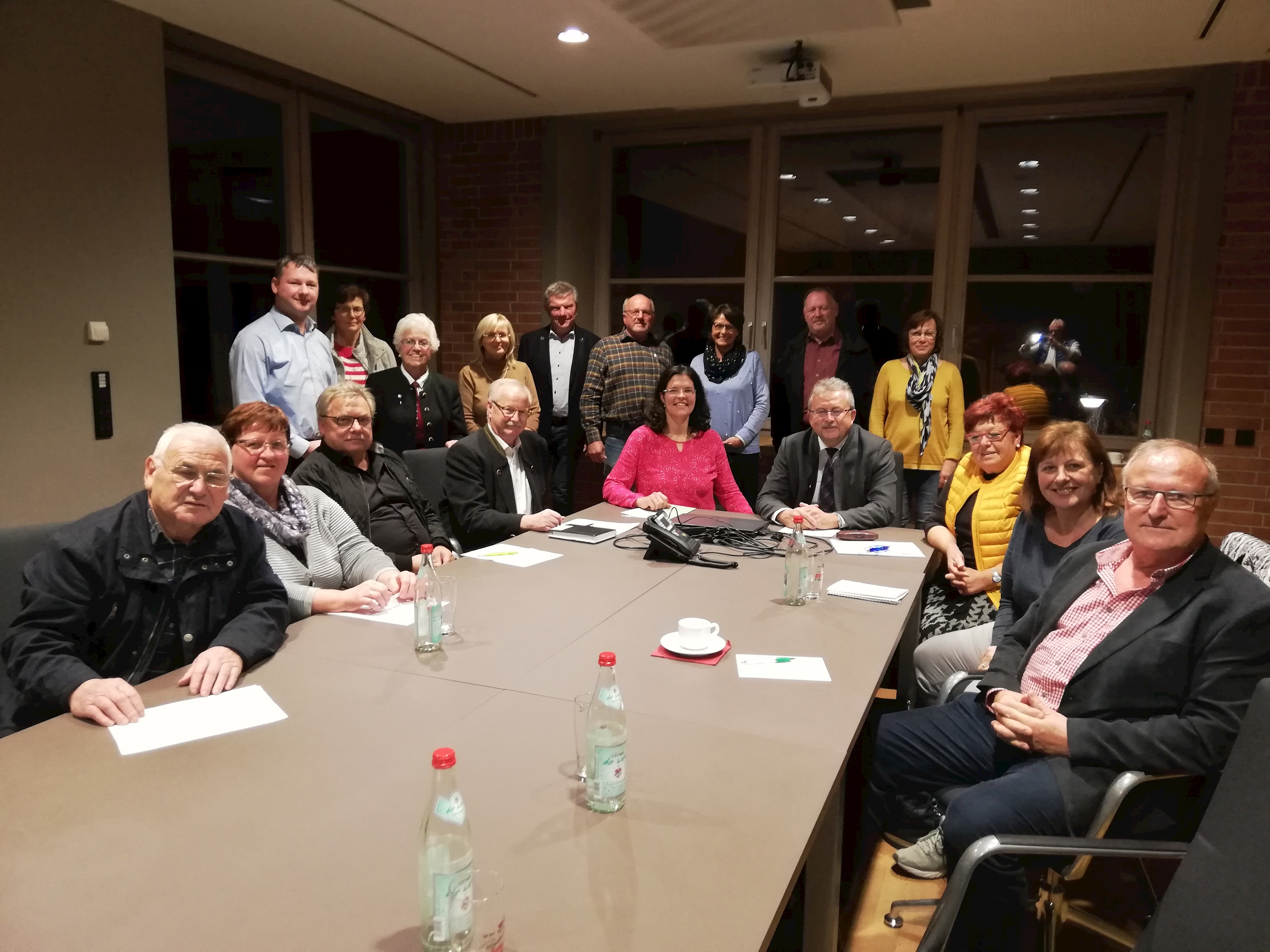 Die Teilnehmer am Treffen der Seniorenbeauftragten sitzend am Tisch im Kleinen Sitzungssaal des Landratsamtes gemeinsam mit Kathrin Haberl und Landrat Josef Laumer (beide am Tischende sitzend).