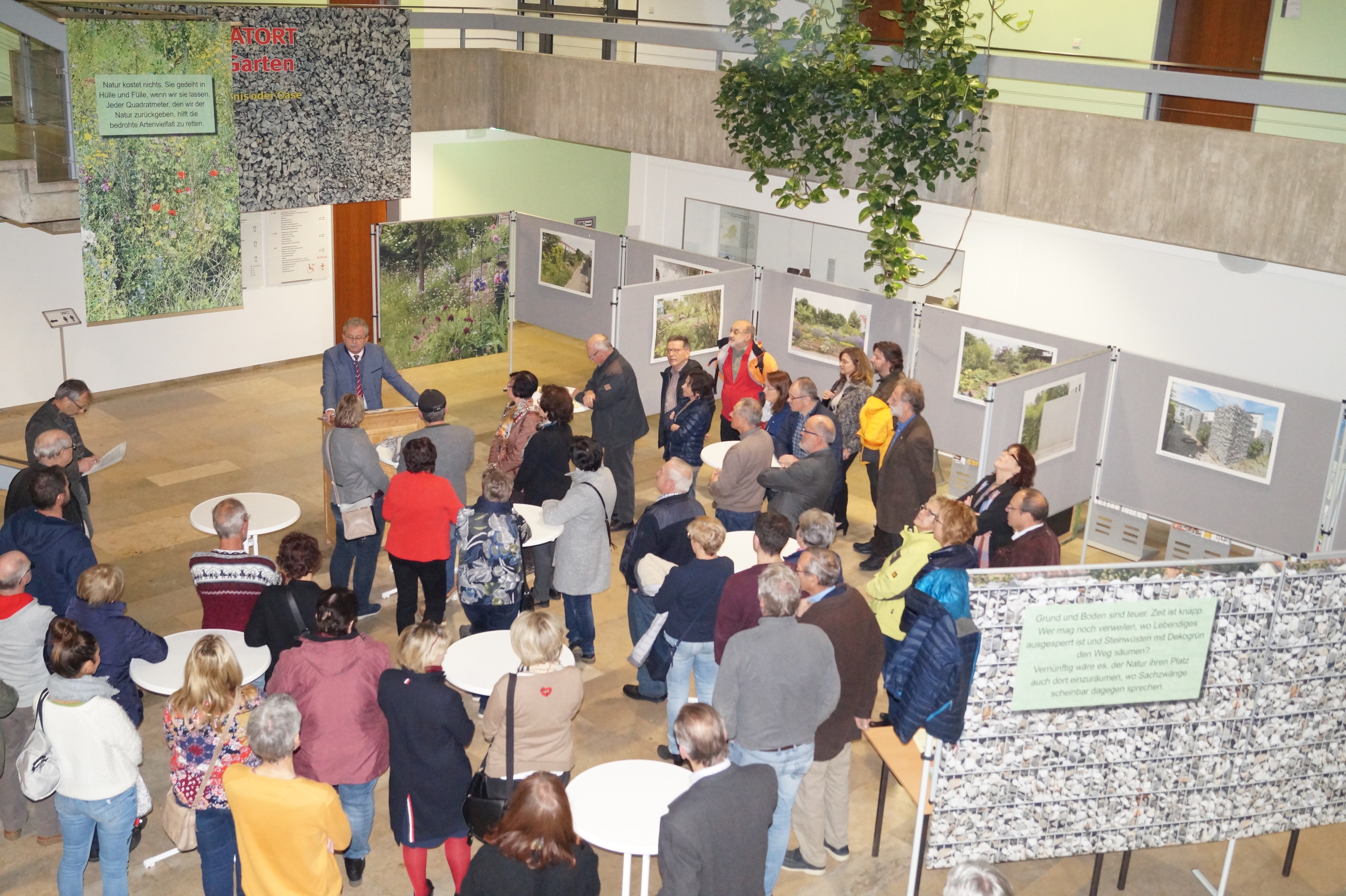 Die Gäste stehen im Foyer des Landratsamtes bei der Ausstellungseröffnung.