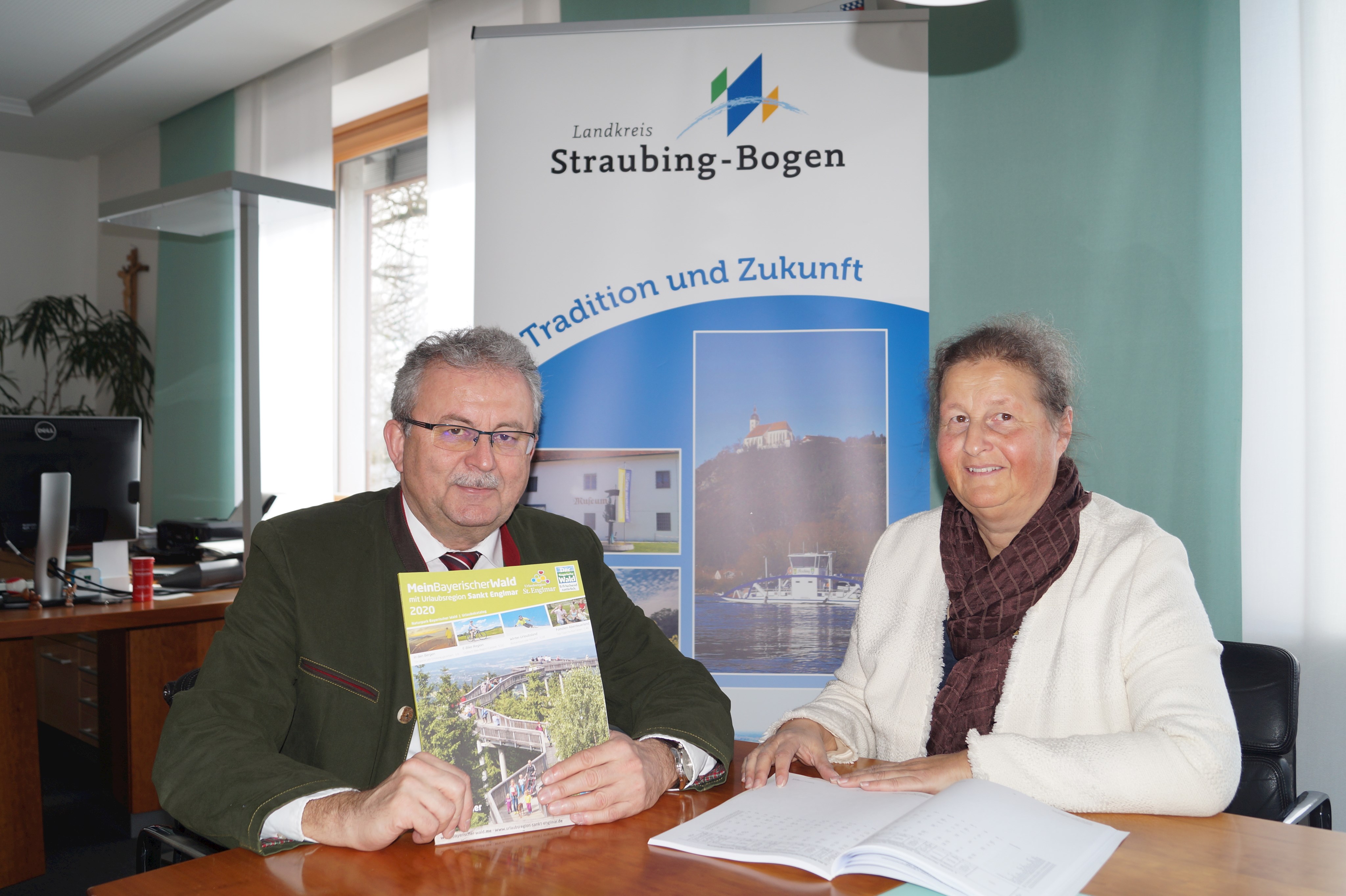 Landrat Josef Laumer und Tourismusreferentin Birgit von Byern freuen sich am Tisch im Büro des Landrats über die guten Zahlen der Tourismus-Statistik 2019 im Landkreis Straubing-Bogen.